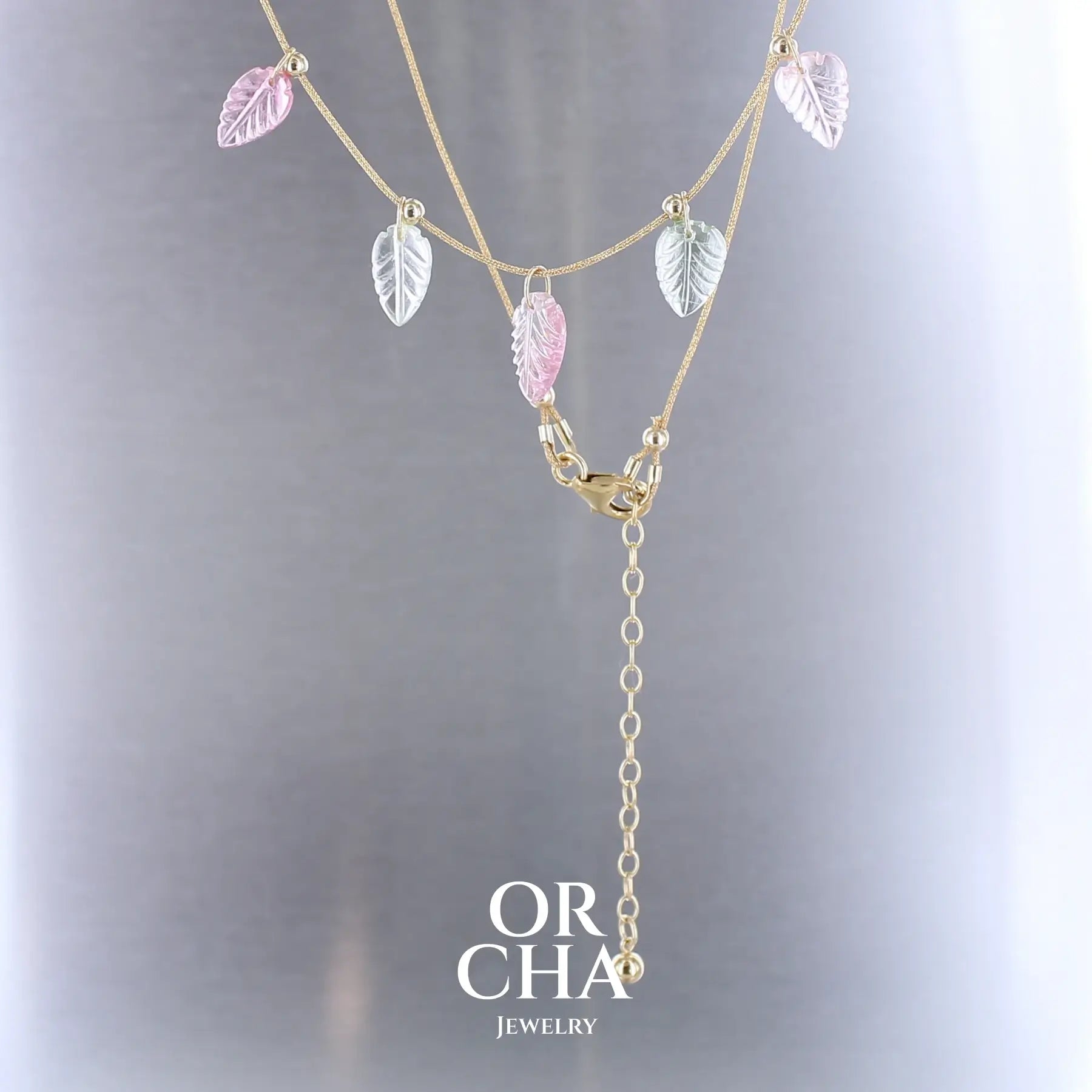 Collier pour femme orné de tourmalines roses et vertes sculptées à la main en 3 dimensions en forme de feuilles serties en or 18k. Les breloques sont montées sur un collier corde doré scintillant, les apprêts utilisé sont en Gold filled ( or laminé ). Longueur ajustable de 40 cm à 45 cm. Bijoux unique, éthique et durable présenté dans un coffret de notre marque, prêt à offrir. Livraison offerte, certificat d'authenticité, service client.