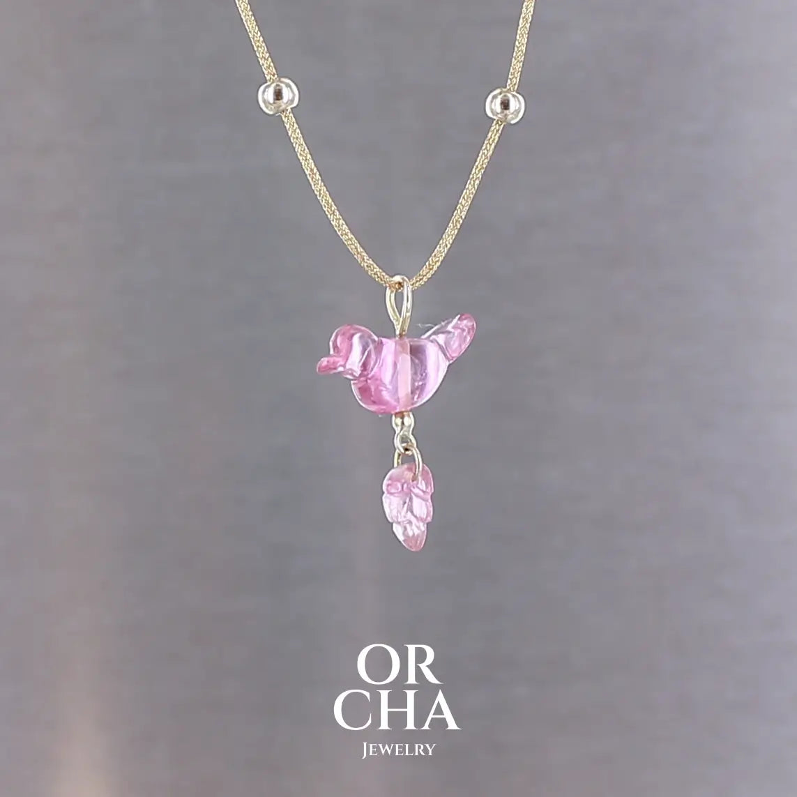 Collier pour femme orné d'une tourmaline rose sculptée à la main en 3 dimensions en forme d'oiseau et de feuille, serties en or 18k. Le pendentif est monté sur un collier corde doré scintillant, les apprêts utilisé sont en Gold filled ( or laminé ). Longueur ajustable de 40 cm à 45 cm. Bijoux unique, éthique et durable présenté dans un coffret de notre marque, prêt à offrir. Livraison offerte, certificat d'authenticité, service client.
