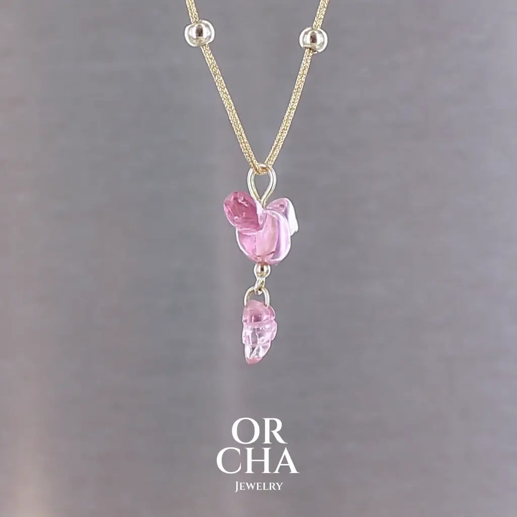 Collier pour femme orné d'une tourmaline rose sculptée à la main en 3 dimensions en forme d'oiseau et de feuille, serties en or 18k. Le pendentif est monté sur un collier corde doré scintillant, les apprêts utilisé sont en Gold filled ( or laminé ). Longueur ajustable de 40 cm à 45 cm. Bijoux unique, éthique et durable présenté dans un coffret de notre marque, prêt à offrir. Livraison offerte, certificat d'authenticité, service client.