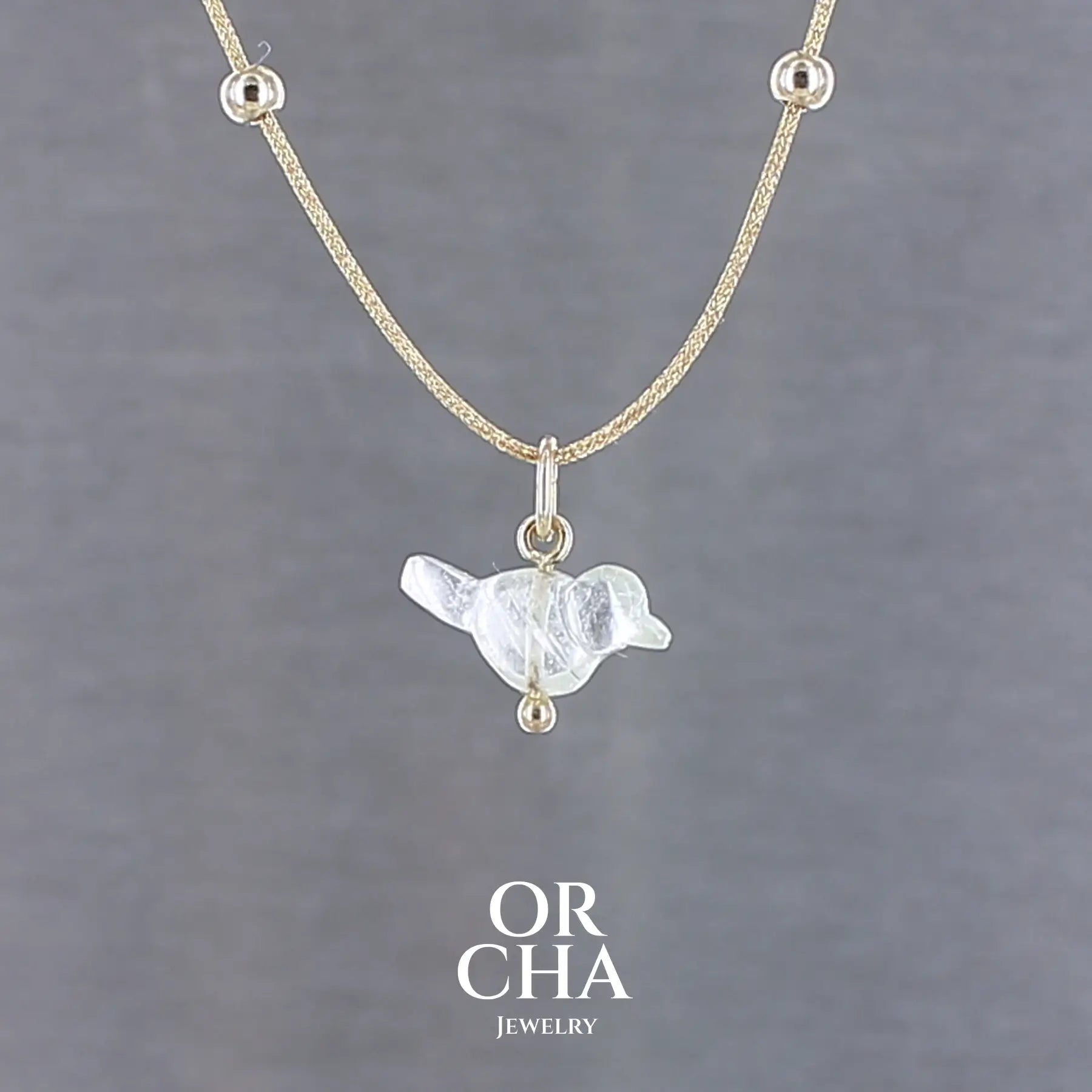 Collier pour femme orné d'une tourmaline vert d'eau très clair, sculptée à la main en 3 dimensions en forme d'oiseau, sertie en or 18k. Le pendentif est monté sur un collier corde doré scintillant, les apprêts utilisé sont en Gold filled ( or laminé ). Longueur ajustable de 40 cm à 45 cm. Bijoux unique, éthique et durable présenté dans un coffret de notre marque, prêt à offrir. Livraison offerte, certificat d'authenticité, service client.
