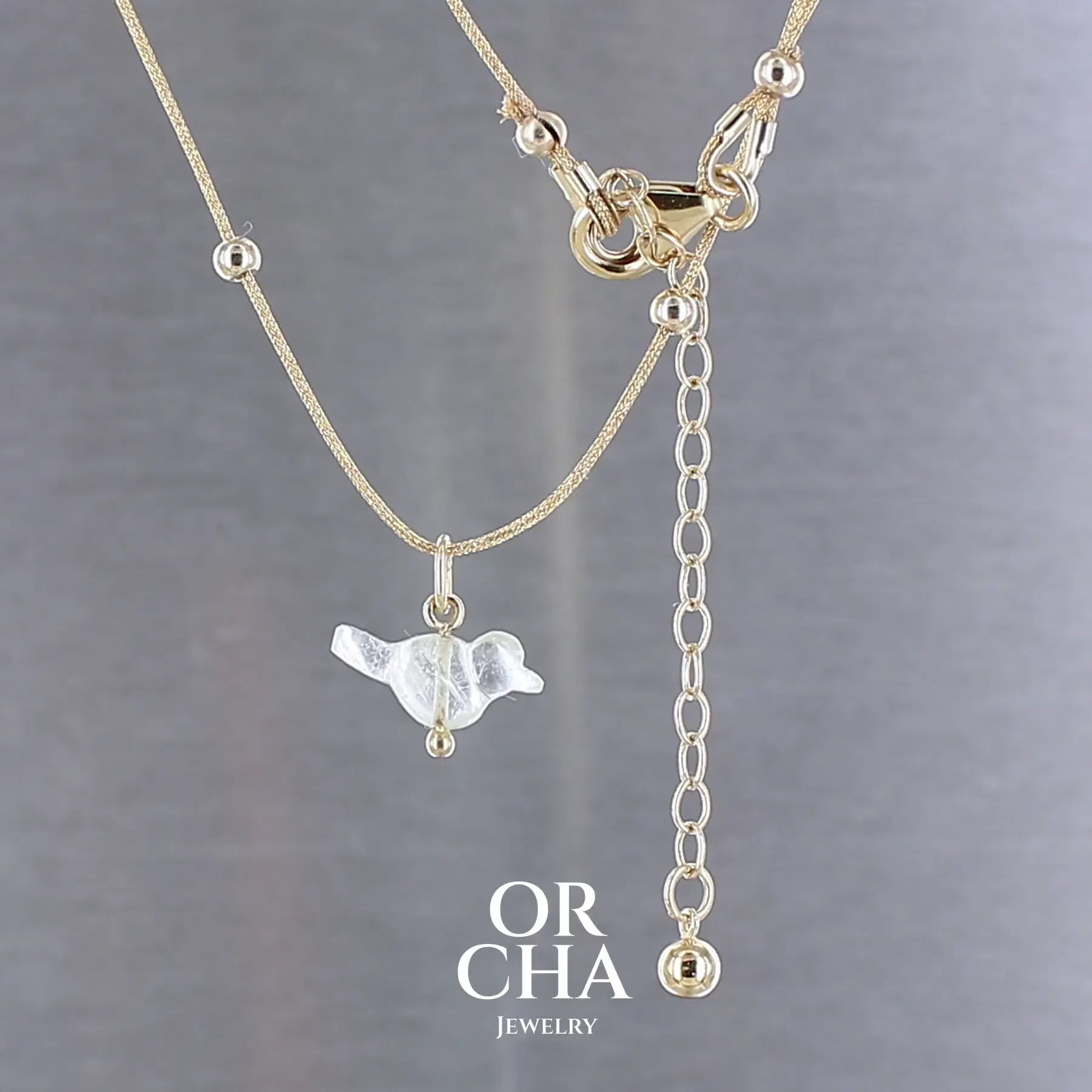 Collier pour femme orné d'une tourmaline vert d'eau très clair, sculptée à la main en 3 dimensions en forme d'oiseau, sertie en or 18k. Le pendentif est monté sur un collier corde doré scintillant, les apprêts utilisé sont en Gold filled ( or laminé ). Longueur ajustable de 40 cm à 45 cm. Bijoux unique, éthique et durable présenté dans un coffret de notre marque, prêt à offrir. Livraison offerte, certificat d'authenticité, service client.
