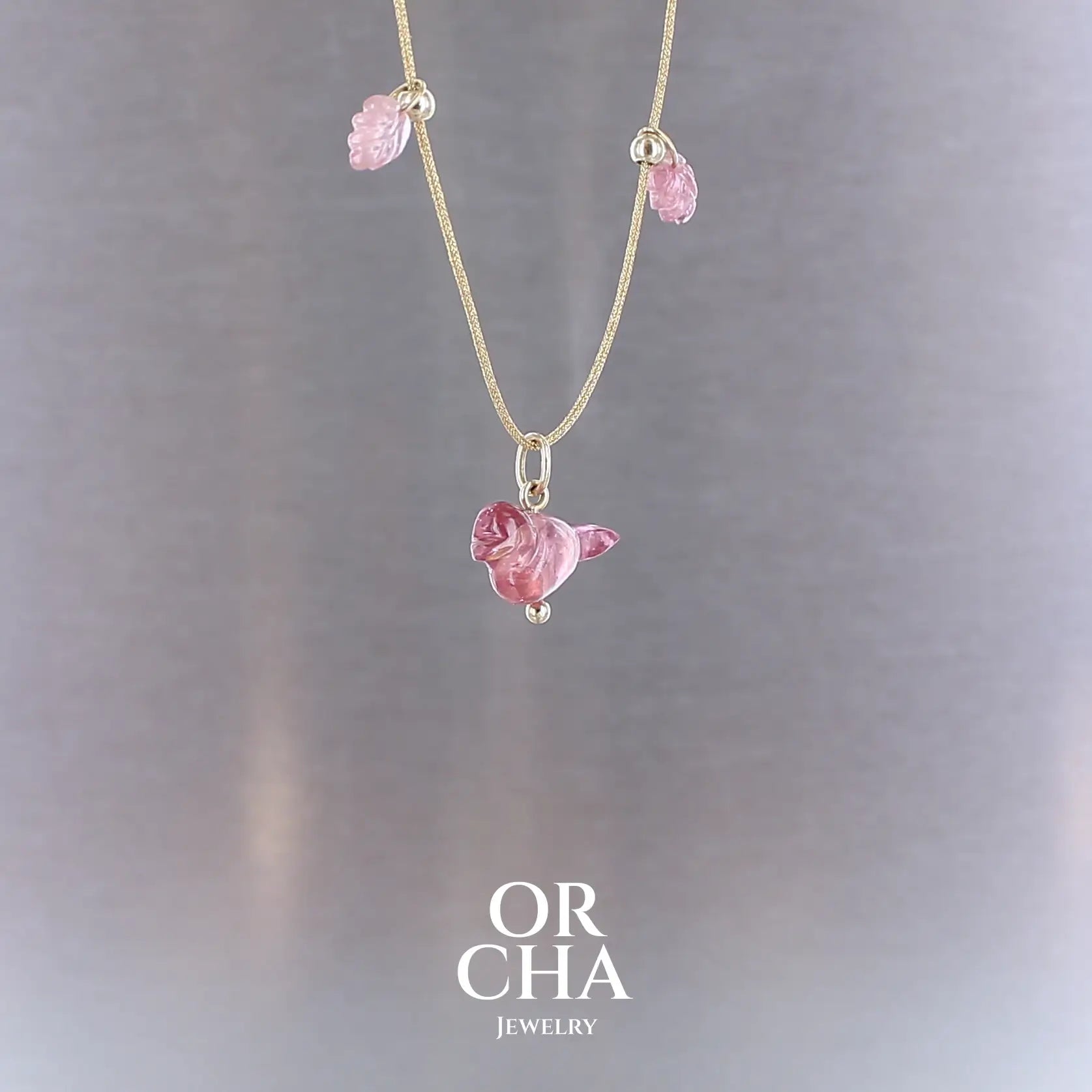 Collier pour femme orné de tourmalines roses sculptées à la main en 3 dimensions en forme d'oiseau et de feuilles, serties en or 18k. Les pendentifs sont montés sur un collier corde doré scintillant, les apprêts utilisé sont en Gold filled ( or laminé ). Longueur ajustable de 40 cm à 45 cm. Bijoux unique, éthique et durable présenté dans un coffret de notre marque, prêt à offrir. Livraison offerte, certificat d'authenticité, service client.