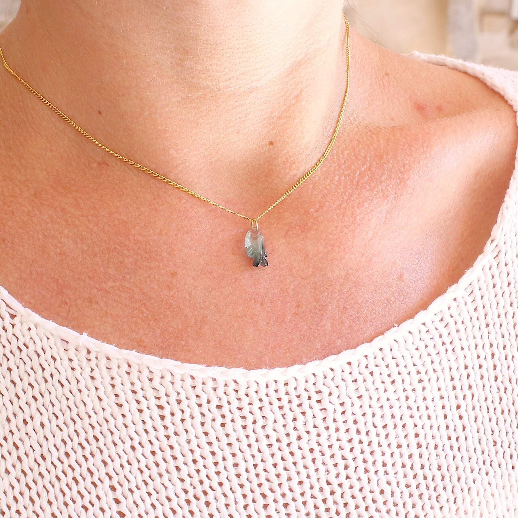 Collier pour femme orné d'une tourmaline bleue sculptée à la main en 3 dimensions en forme de poisson sertie en or 18k. Le pendentif est monté sur une chaine en Gold filled ( or laminé ) d'une longueur de 45 cm. Bijoux unique, éthique et durable présenté dans un coffret de notre marque, prêt à offrir. Livraison offerte, certificat d'authenticité, service client.
