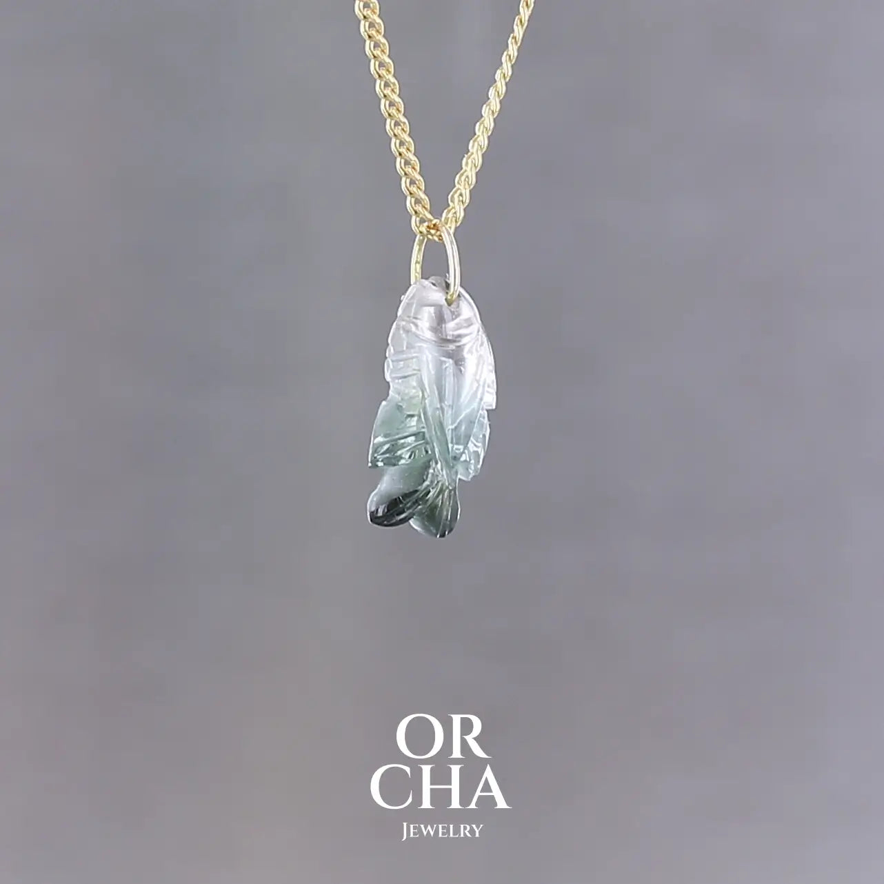 Collier pour femme orné d'une tourmaline bleue sculptée à la main en 3 dimensions en forme de poisson sertie en or 18k. Le pendentif est monté sur une chaine en Gold filled ( or laminé ) d'une longueur de 45 cm. Bijoux unique, éthique et durable présenté dans un coffret de notre marque, prêt à offrir. Livraison offerte, certificat d'authenticité, service client.