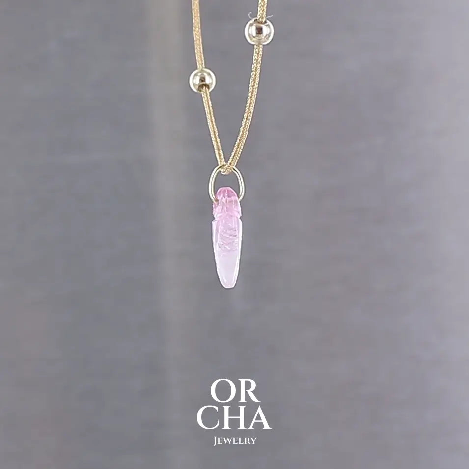 Collier pour femme orné d'une tourmaline rose sculptée à la main en 3 dimensions en forme de poisson sertie en or 18k. Le pendentif est monté sur un collier corde doré scintillant, les apprêts utilisé sont en Gold filled ( or laminé ). Longueur ajustable de 40 cm à 45 cm. Bijoux unique, éthique et durable présenté dans un coffret de notre marque, prêt à offrir. Livraison offerte, certificat d'authenticité, service client.