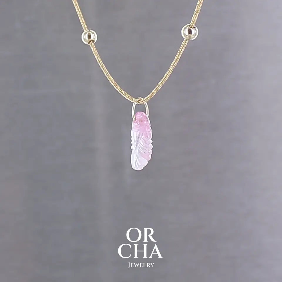 Collier pour femme orné d'une tourmaline rose sculptée à la main en 3 dimensions en forme de poisson sertie en or 18k. Le pendentif est monté sur un collier corde doré scintillant, les apprêts utilisé sont en Gold filled ( or laminé ). Longueur ajustable de 40 cm à 45 cm. Bijoux unique, éthique et durable présenté dans un coffret de notre marque, prêt à offrir. Livraison offerte, certificat d'authenticité, service client.