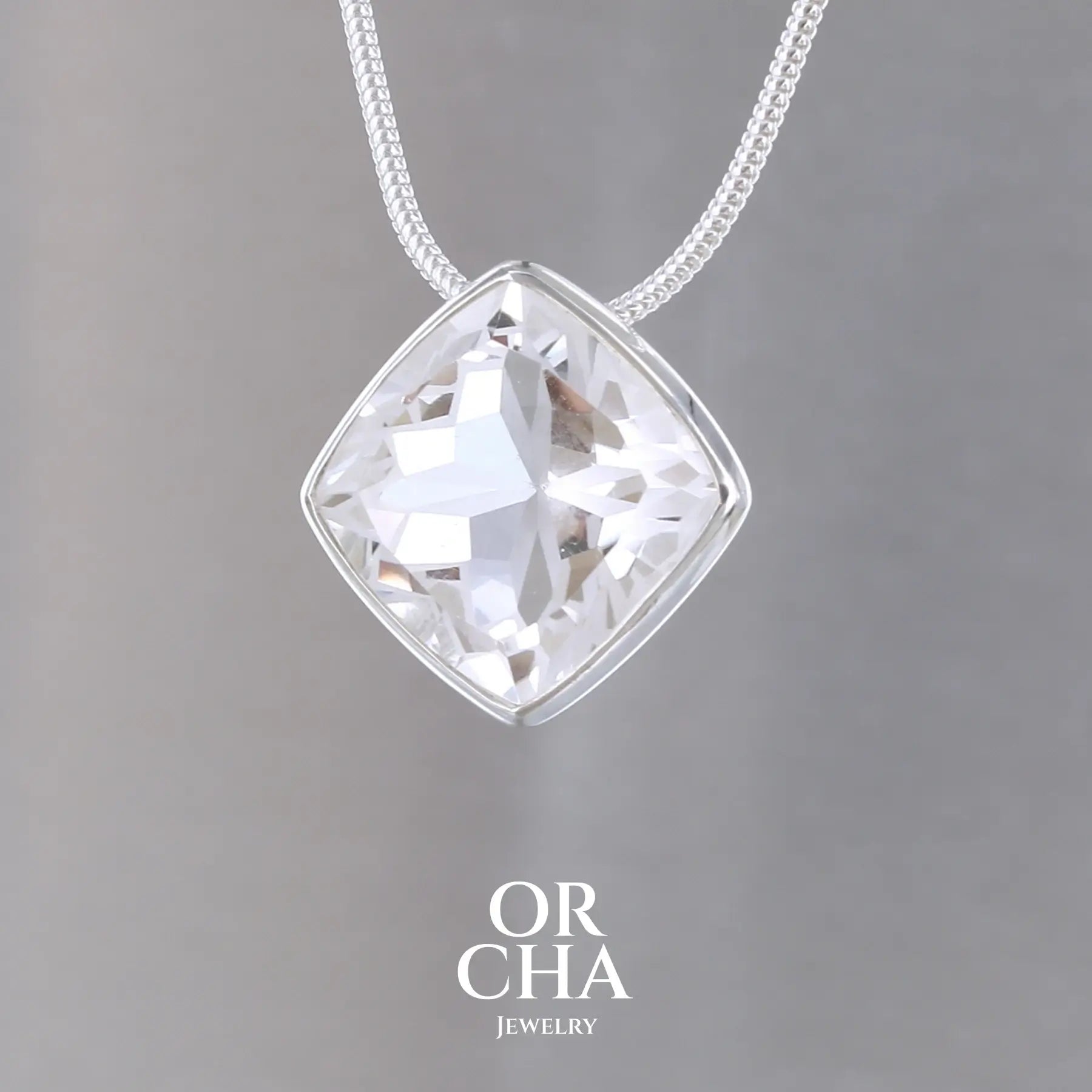 collier solitaire pour femme en argent massif sertie d'un Cristal de roche gravé d'une fleur de vie. Pierre facettée de forme carrée de qualité transparente, propre à l'oeil. Pierre naturelle incolore et blanche sur les parties gravées. Pendentif monté sur une chaine en argent sterling de type maille serpent de 1,2 mm d'épaisseur et de 40 cm de longueur. Bijoux unique, éthique et durable présenté dans un coffret de notre marque, prêt à offrir. Livraison offerte, certificat d'authenticité, service client.