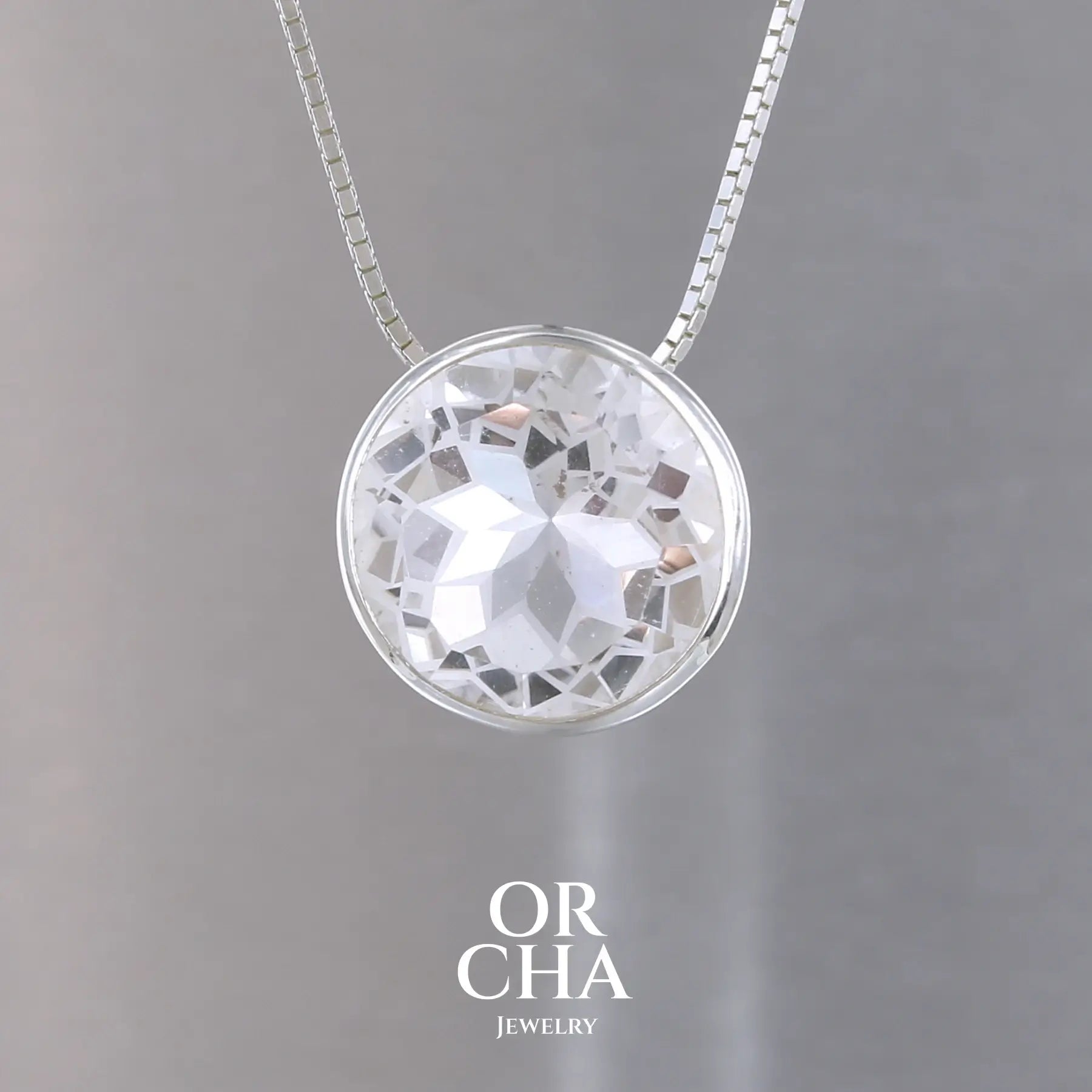 collier solitaire pour femme en argent massif sertie d'un Cristal de roche gravé d'une fleur de vie. Pierre facettée de forme ronde de qualité transparente, propre à l'oeil. Pierre naturelle incolore et blanche sur les parties gravées. Pendentif monté sur une chaine en argent sterling de type maille miroir de 0,94 mm d'épaisseur et de 40 cm de longueur. Bijoux unique, éthique et durable présenté dans un coffret de notre marque, prêt à offrir. Livraison offerte, certificat d'authenticité, service client.