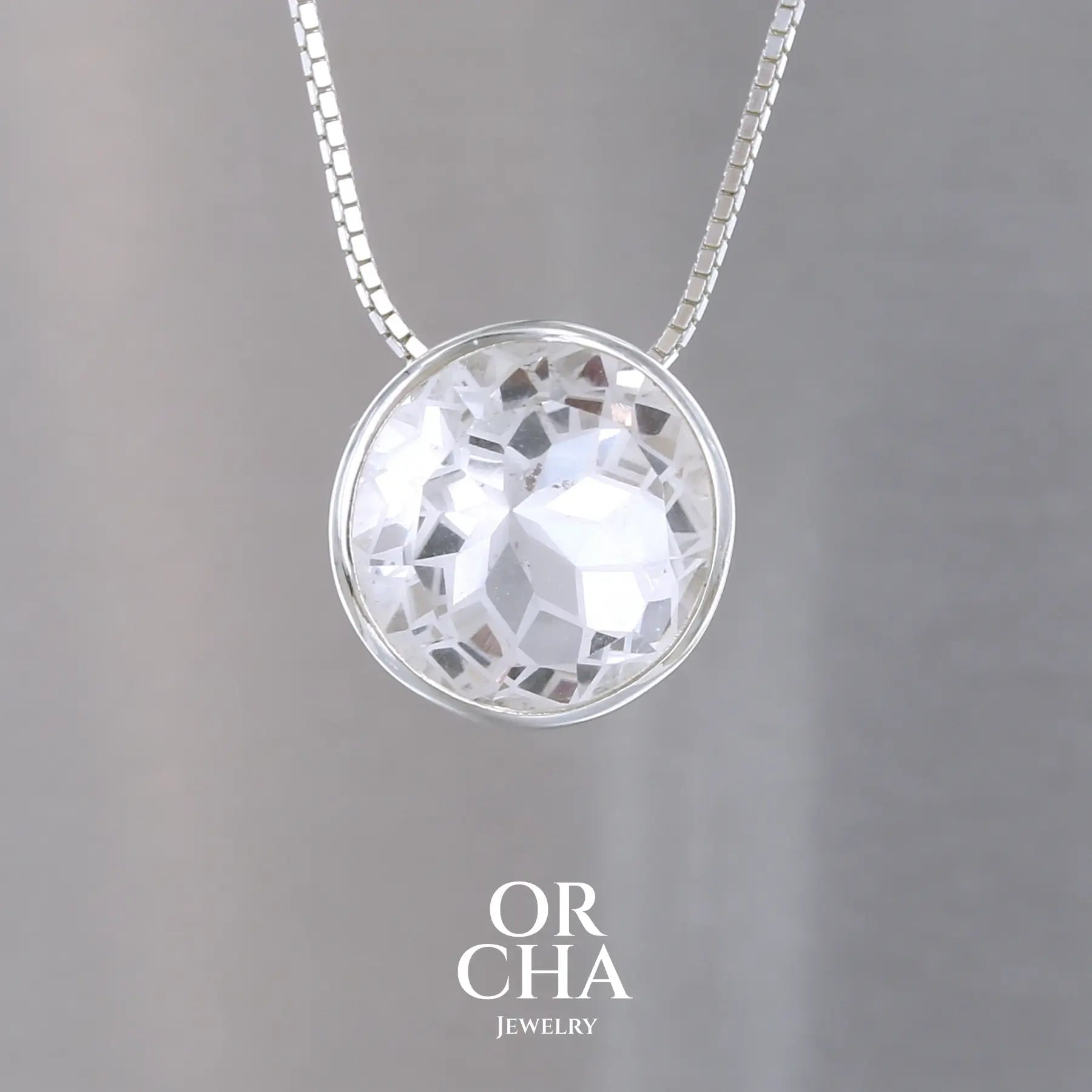 collier solitaire pour femme en argent massif sertie d'un Cristal de roche gravé d'une fleur de vie. Pierre facettée de forme ronde de qualité transparente, propre à l'oeil. Pierre naturelle incolore et blanche sur les parties gravées. Pendentif monté sur une chaine en argent sterling de type maille miroir de 0,94 mm d'épaisseur et de 40 cm de longueur. Bijoux unique, éthique et durable présenté dans un coffret de notre marque, prêt à offrir. Livraison offerte, certificat d'authenticité, service client.