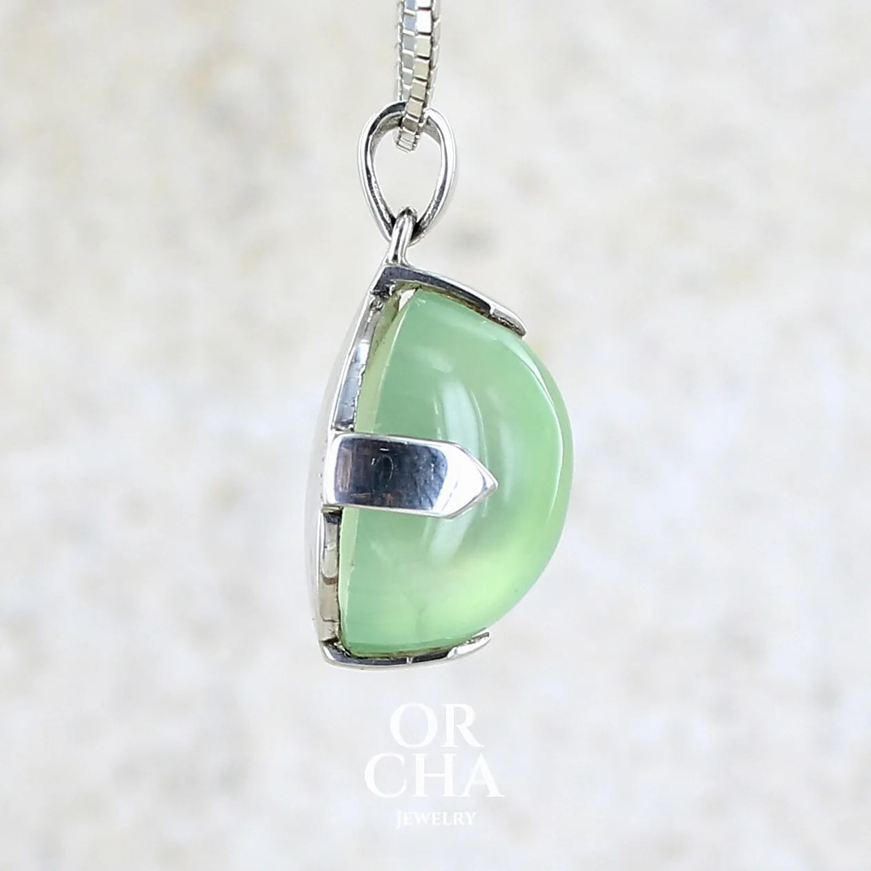detail du sertissage d'un Pendentif ovale en argent massif, serti d'un cabochon de préhnite de couleur verte clair. Pierre de qualité translucide comportant des inclusions. Bijoux unique par Orcha Jewelry