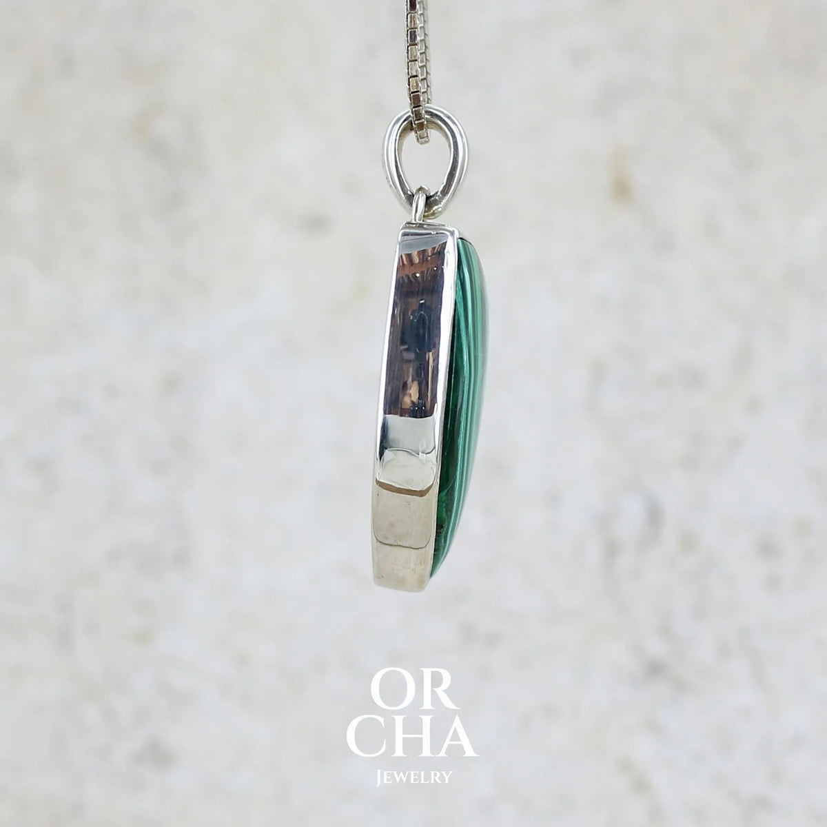 détail du sertissage du pendentif pour femme et homme en argent massif serti d'un cabochon de Malachite de couleur verte clair et vert foncé contrasté. Cabochon en forme de dent de qualité opaque. Bijoux unique réalise par Orchajewelry