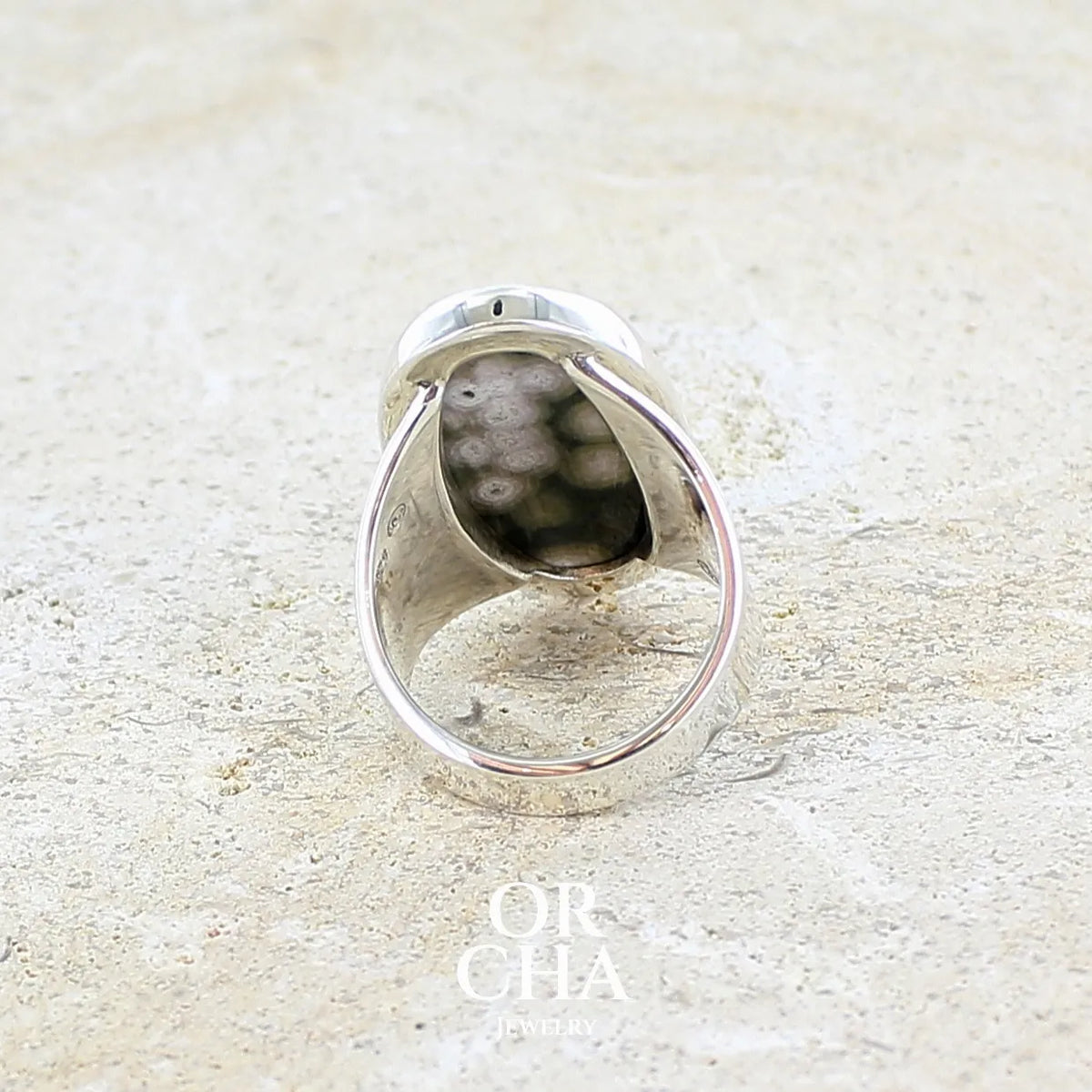 Vue de dos d'une bague pour femme en argent massif sertie d'un cabochon ovale de jaspe orbiculaire de couleur vert kaki, blanc et rosé. Pierre de qualité opaque. Bijou unique réalisée en taille 58 par Orchajewelry