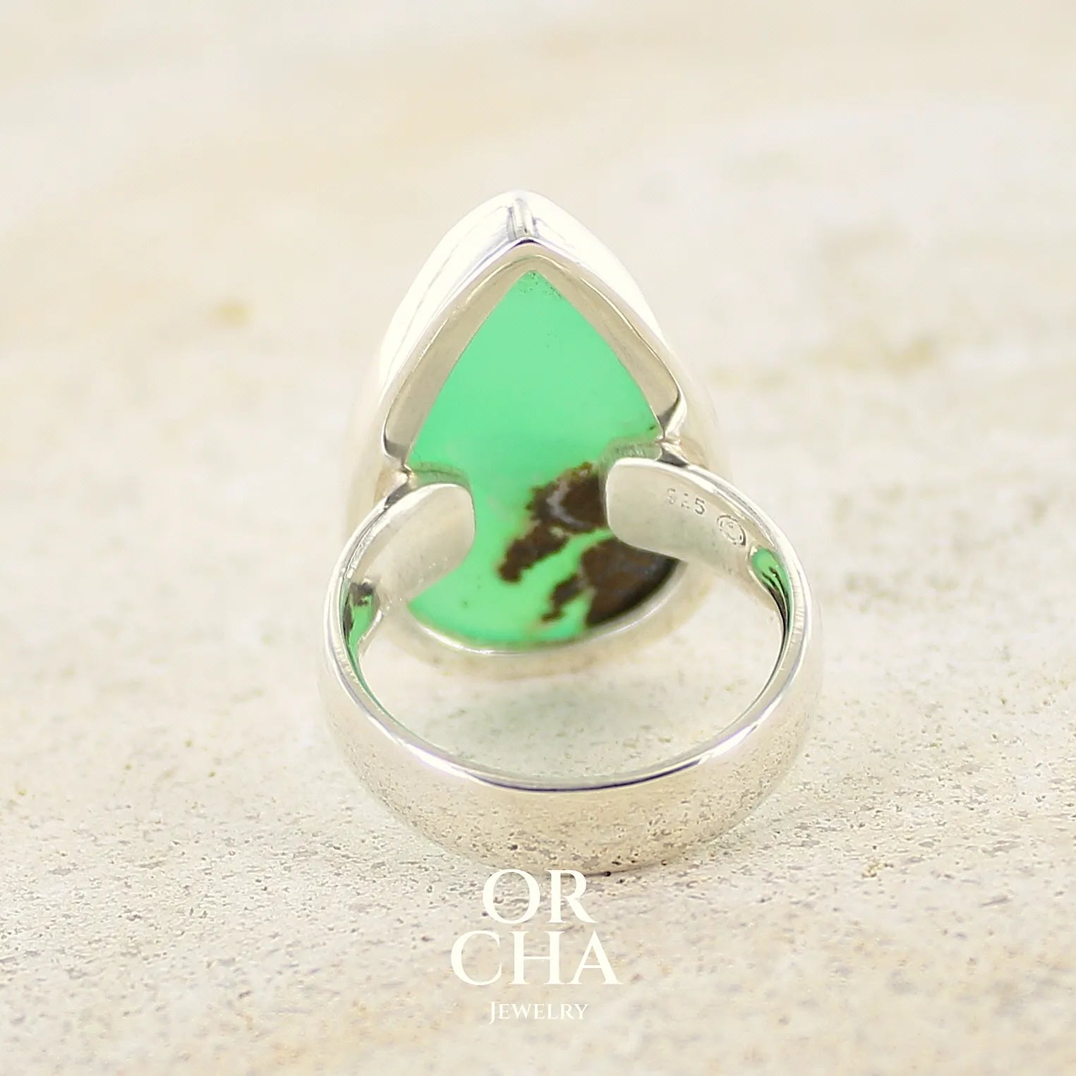Vue de dos d'une bague pour femme en argent massif, sertie d'un cabochon de Chrysoprase. Pierre taillée en forme de goutte de qualité opaque. Bijoux unique réalisé en taille 58 par Orcha Jewelry