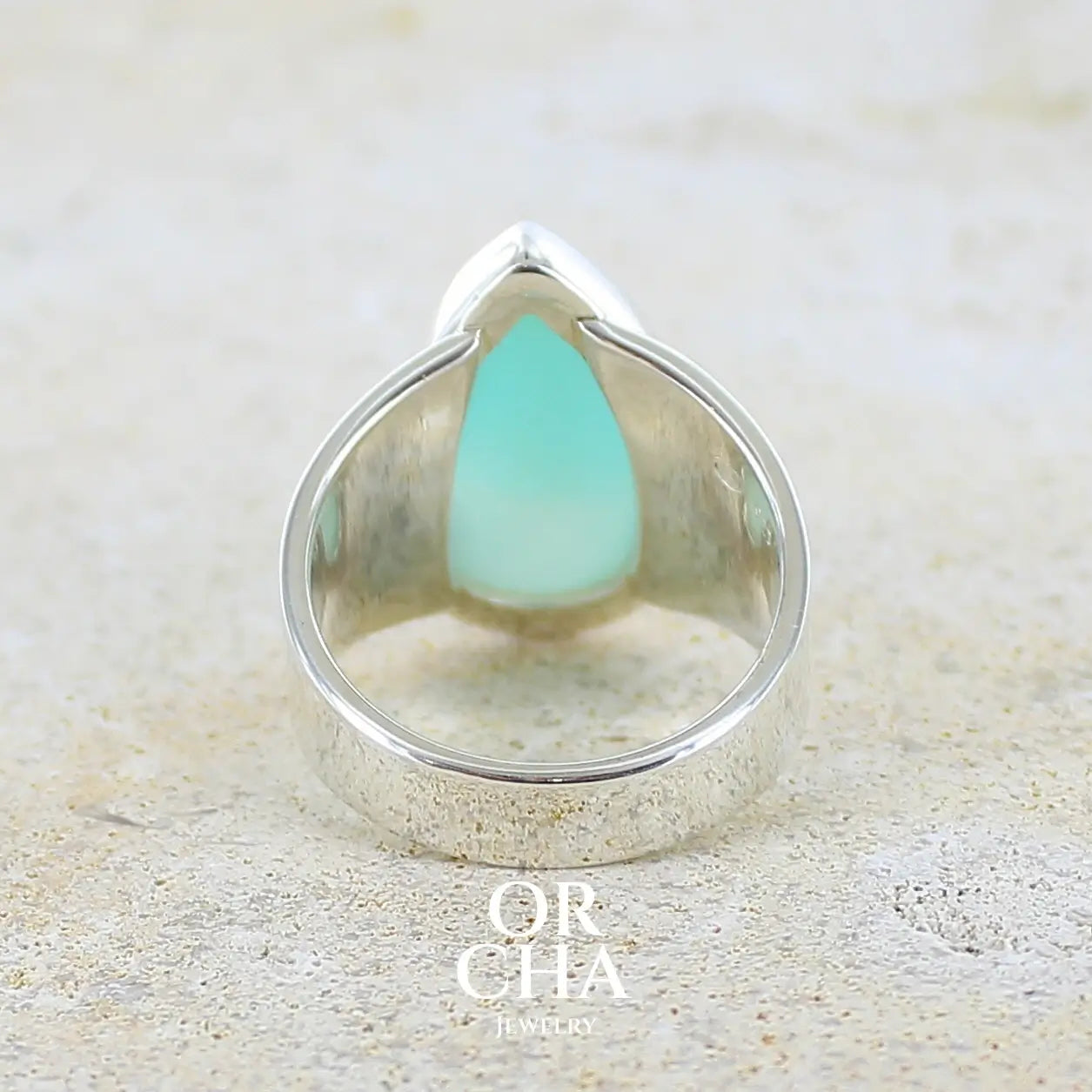 vue de dos d'une bague pour femme en argent massif, sertie d'un cabochon d'opale bleue du Pérou de couleur bleu ciel. Pierre taillée en forme de goutte de qualité opaque. Bijou unique réalisé en taille 58.