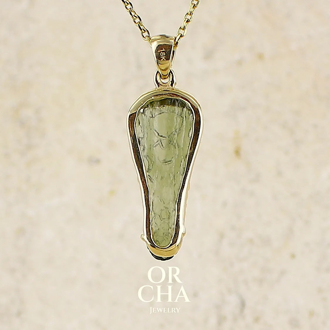 vue de dos d'un pendentif pour homme en or 18k serti d'une moldavite sculptée en tête de crocodile. Pierre naturelle de couleur verte kaki translucide. Bijoux unique par Orcha jewelry