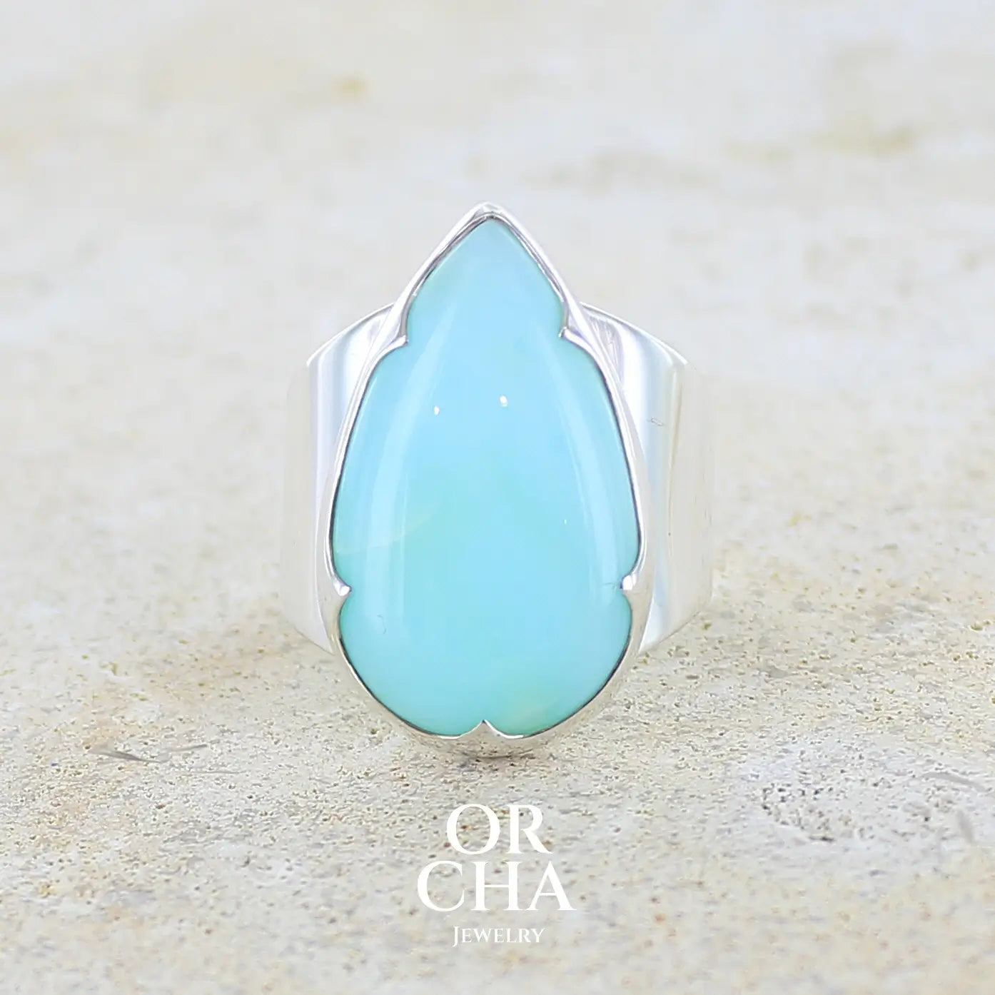 Grande bague pour femme en argent massif, sertie d'un cabochon d'opale bleue du Pérou de couleur bleu ciel. Pierre taillée en forme de goutte de qualité opaque. Bijou unique réalisé en taille 60 FR.