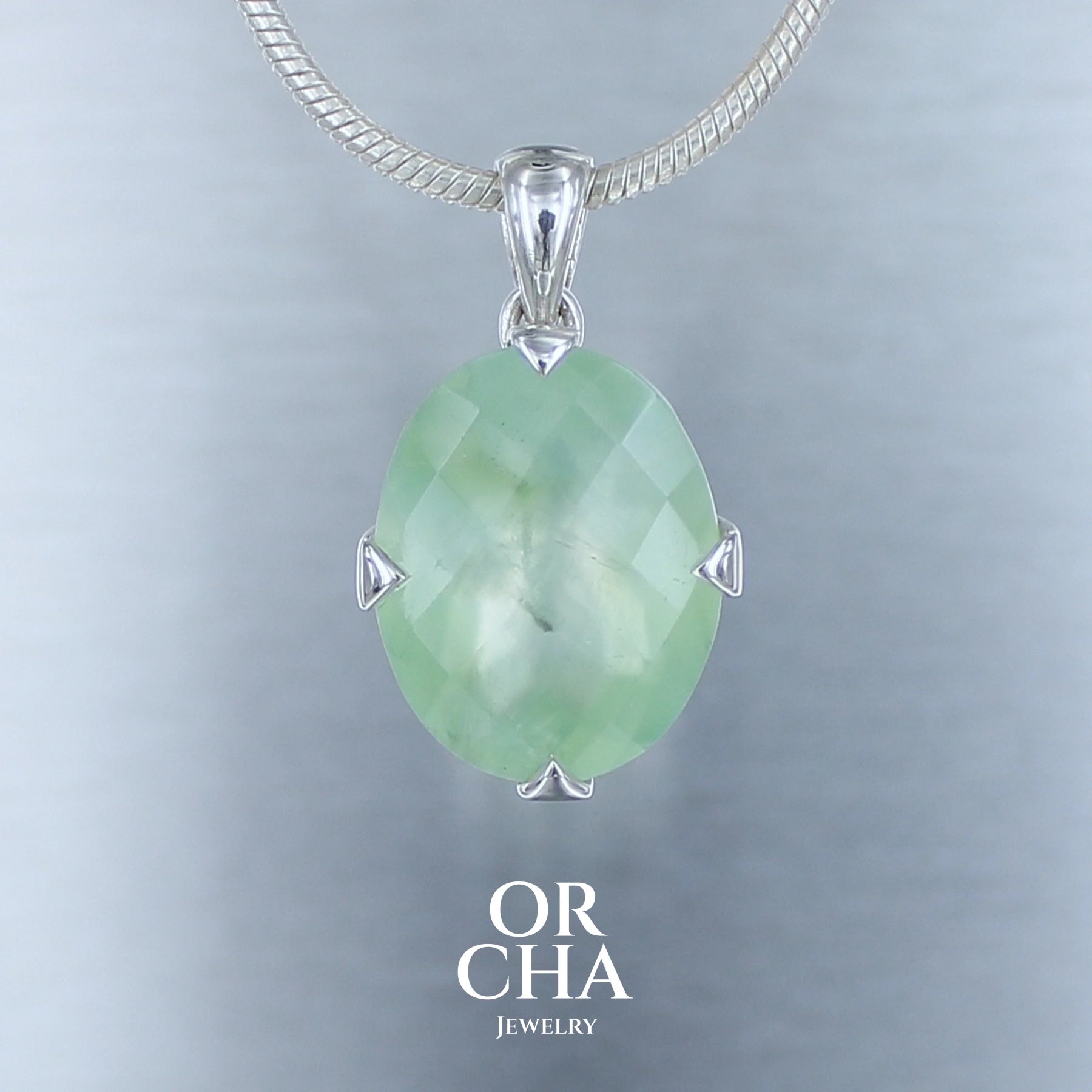pendentifs en argent de forme ovale serti d'un cabochon facetté en surface de préhnite, pierre naturelle de couleur vert clair translucide