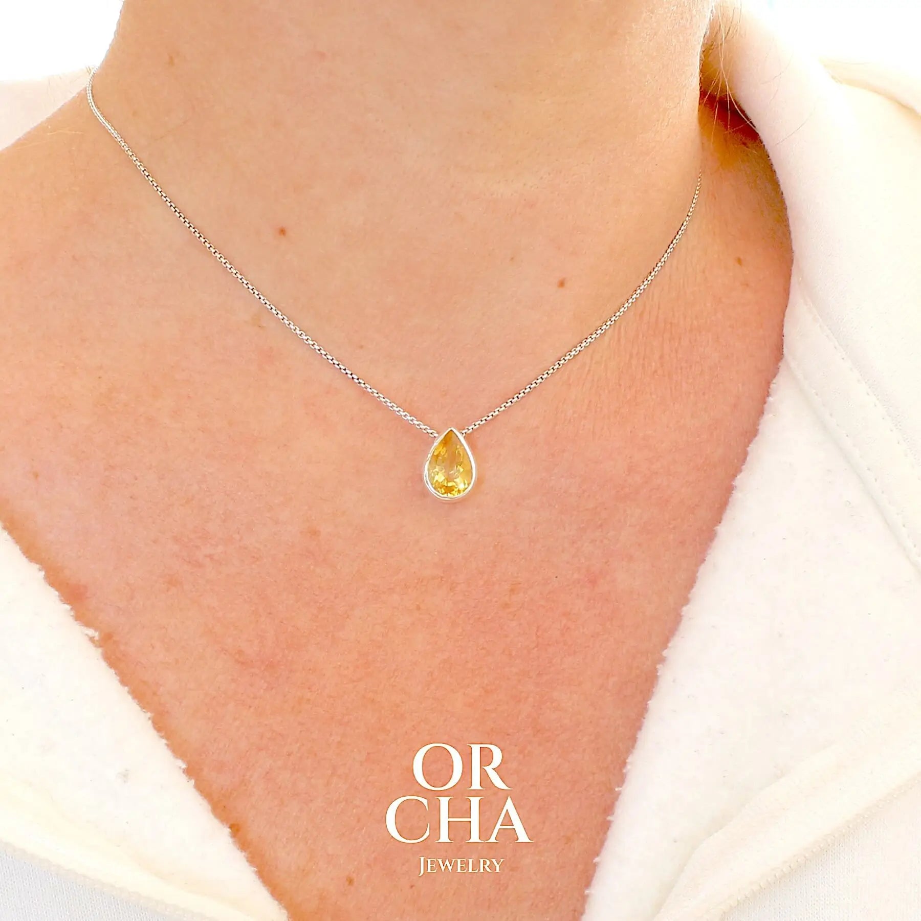 Collier solitaire pour femme en argent massif serti d'une Citrine. Pierre au nuance de couleur jaune doré lumineux, pierre facettée en forme de goutte, qualité transparente propre à l'oeil. Pendentif monté sur une chaine en argent sterling de type maille vénitienne de 1,3 mm d'épaisseur et de 40 cm de longueur. Bijoux unique, éthique et durable présenté dans un coffret de notre marque, prêt à offrir. Livraison offerte, certificat d'authenticité, service client. Par Orcha Jewelry