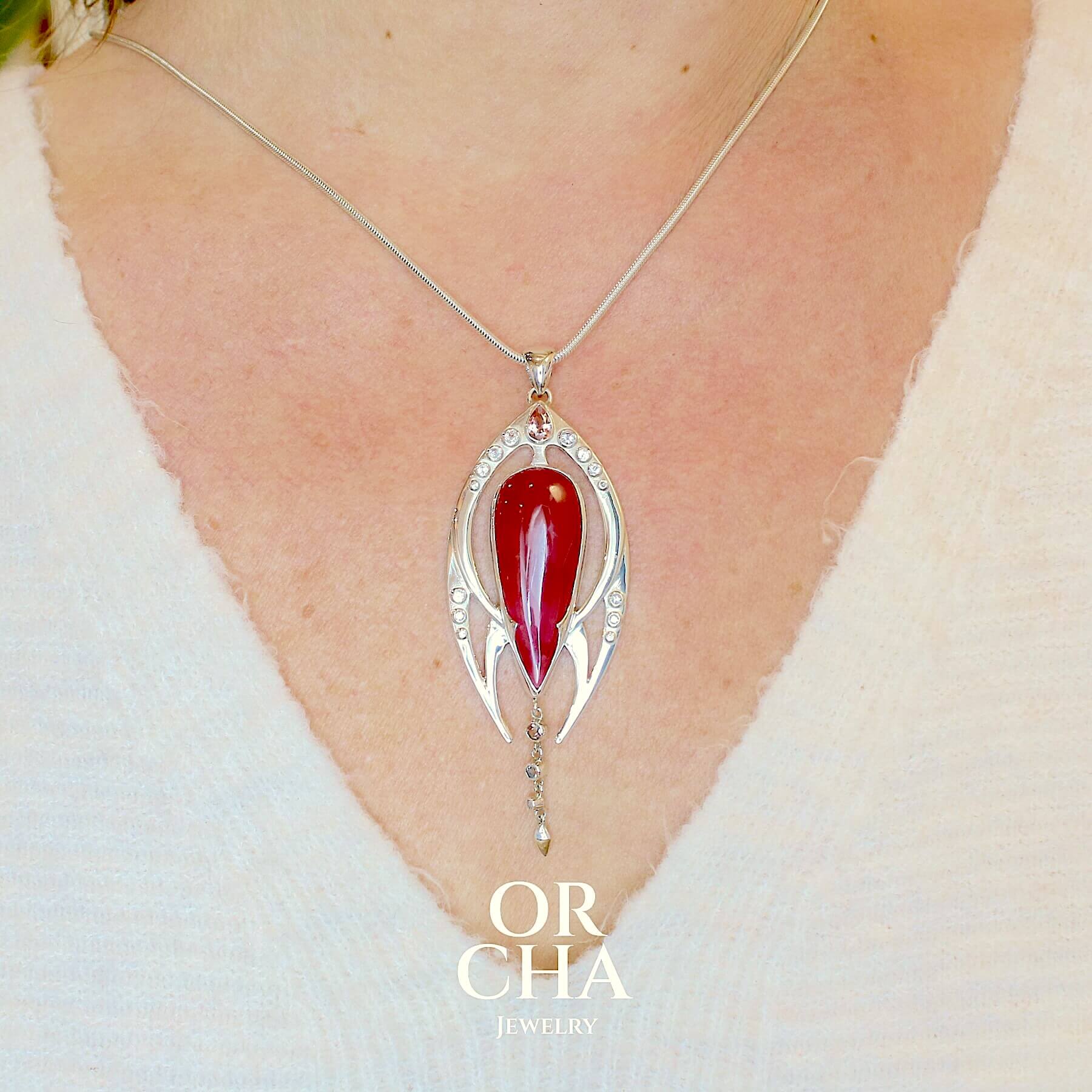 Pendentif exclusif, création originale, pour femme en argent massif serti d'une Rhodonite de très belle qualité, d'une tourmaline et de goshénite. Pierre de couleur rouge coquelicot, rose pastel et blanche, translucide à transparentes. Pierre naturelle, en forme de goutte, taillée en cabochon. Bijoux unique, éthique et durable présenté dans un coffret de notre marque, prêt à offrir. Livraison offerte, certificat d'authenticité, service client