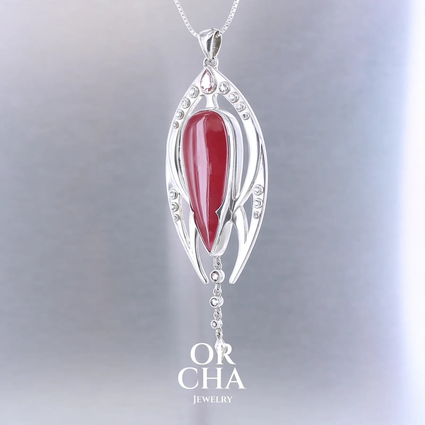 Pendentif exclusif, création originale, pour femme en argent massif serti d'une Rhodonite de très belle qualité, d'une tourmaline et de goshénite. Pierre de couleur rouge coquelicot, rose pastel et blanche, translucide à transparentes. Pierre naturelle, en forme de goutte, taillée en cabochon. Bijoux unique, éthique et durable présenté dans un coffret de notre marque, prêt à offrir. Livraison offerte, certificat d'authenticité, service client