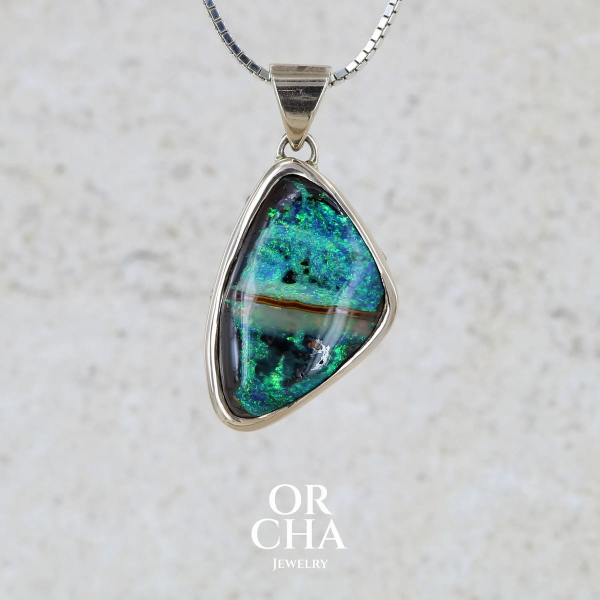 Pendentif pour femme en or 9k massif et argent massif 925 serti d'une opale boulder aux feux multicolores à dominantes bleu turquoise et vert et de six diamants. Pierre cabochon de qualité opaque taillée en forme d'aile. Bijou unique par Orchajewelry