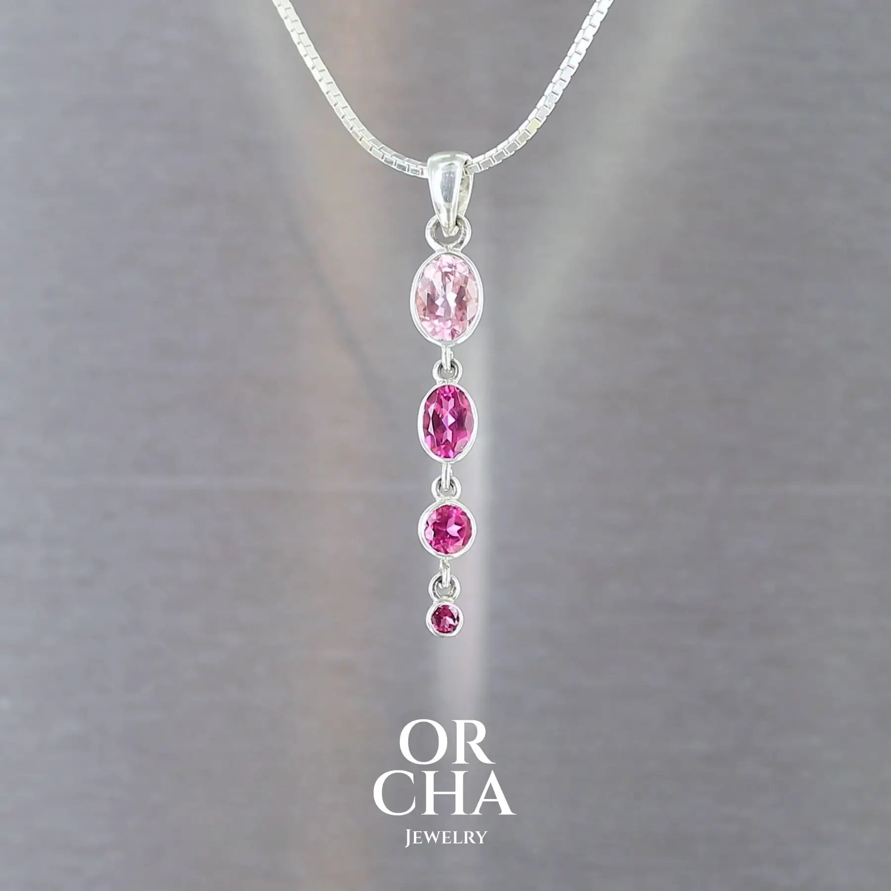 pendentif pour femme en argent massif serti en ligne de 4 tourmalines roses fuchsia et rose bonbon. Pierres facettées transparentes propre à l'oeil. Bijoux unique, éthique et durable présenté dans un coffret de notre marque, prêt à offrir. Livraison offerte, certificat d'authenticité, service client.