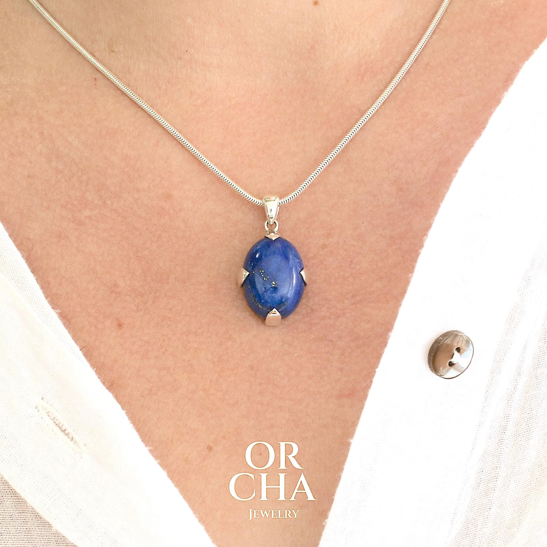 Pendentif ovale en argent massif serti d'un Lapis Lazuli. Pierre naturelle de couleur bleu nuit à inclusions de pyrite dorés, qualité opaque. Bijoux unique, éthique et durable présenté dans un coffret de notre marque, prêt à offrir. Livraison offerte, certificat d'authenticité, service client.