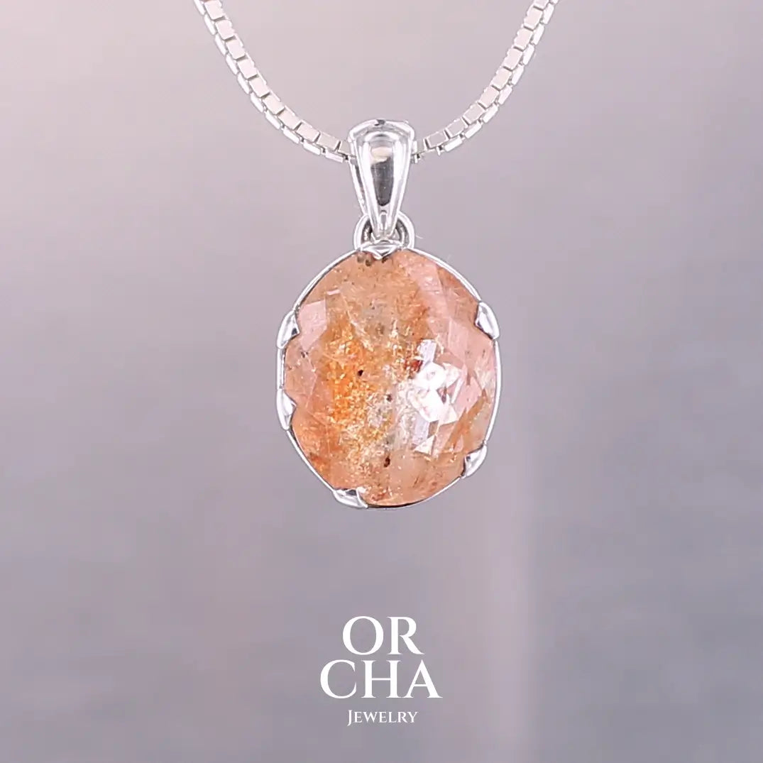 Pendentif en argent massif serti d'une magnifique pierre de soleil. Pierre facettée de forme ovale de qualité transparente. Pierre naturelle de couleur orange clair à scintillement doré et orangé. Bijoux unique, éthique et durable présenté dans un coffret de notre marque, prêt à offrir. Livraison offerte, certificat d'authenticité, service client.