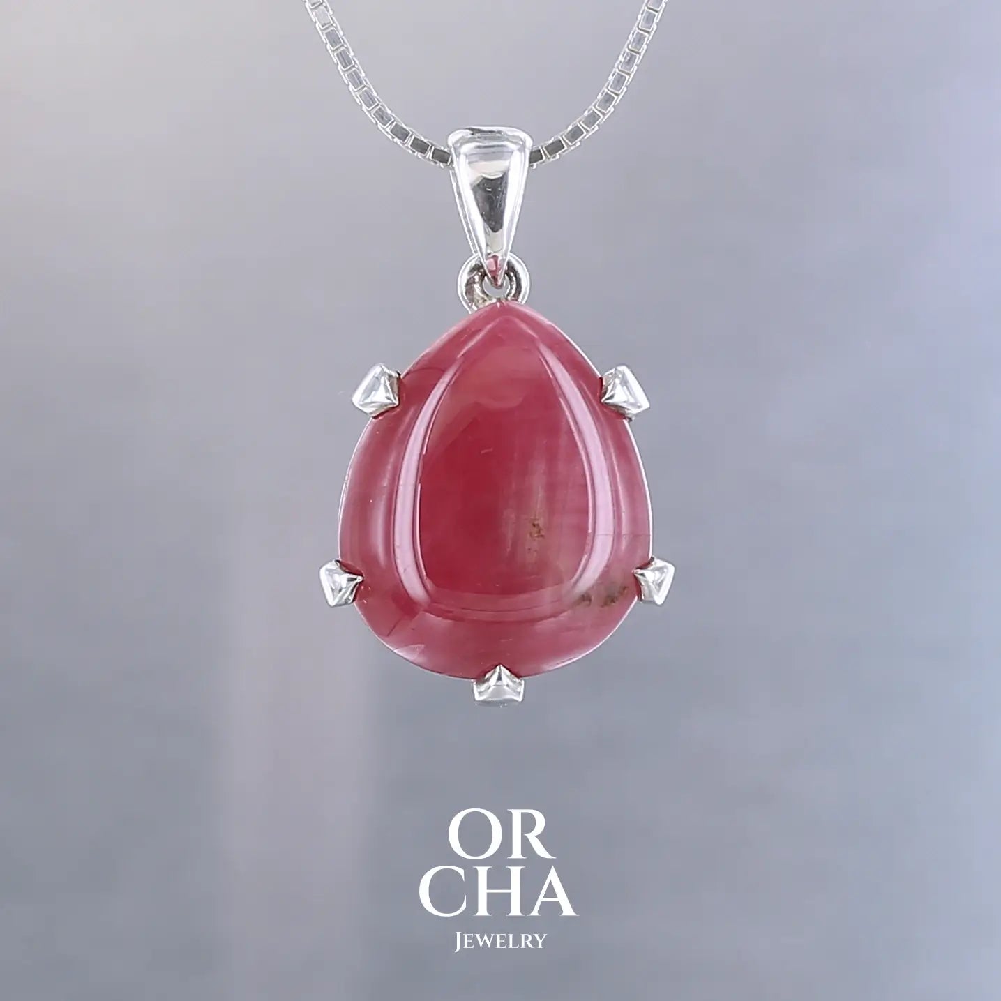 Pendentif pour femme en argent massif serti d'une Rhodonite de belle qualité. Pierre de couleur rouge coquelicot, opaque. Pierre naturelle, en forme de goutte, taillée en cabochon. Bijoux unique, éthique et durable présenté dans un coffret de notre marque, prêt à offrir. Livraison offerte, certificat d'authenticité, service client