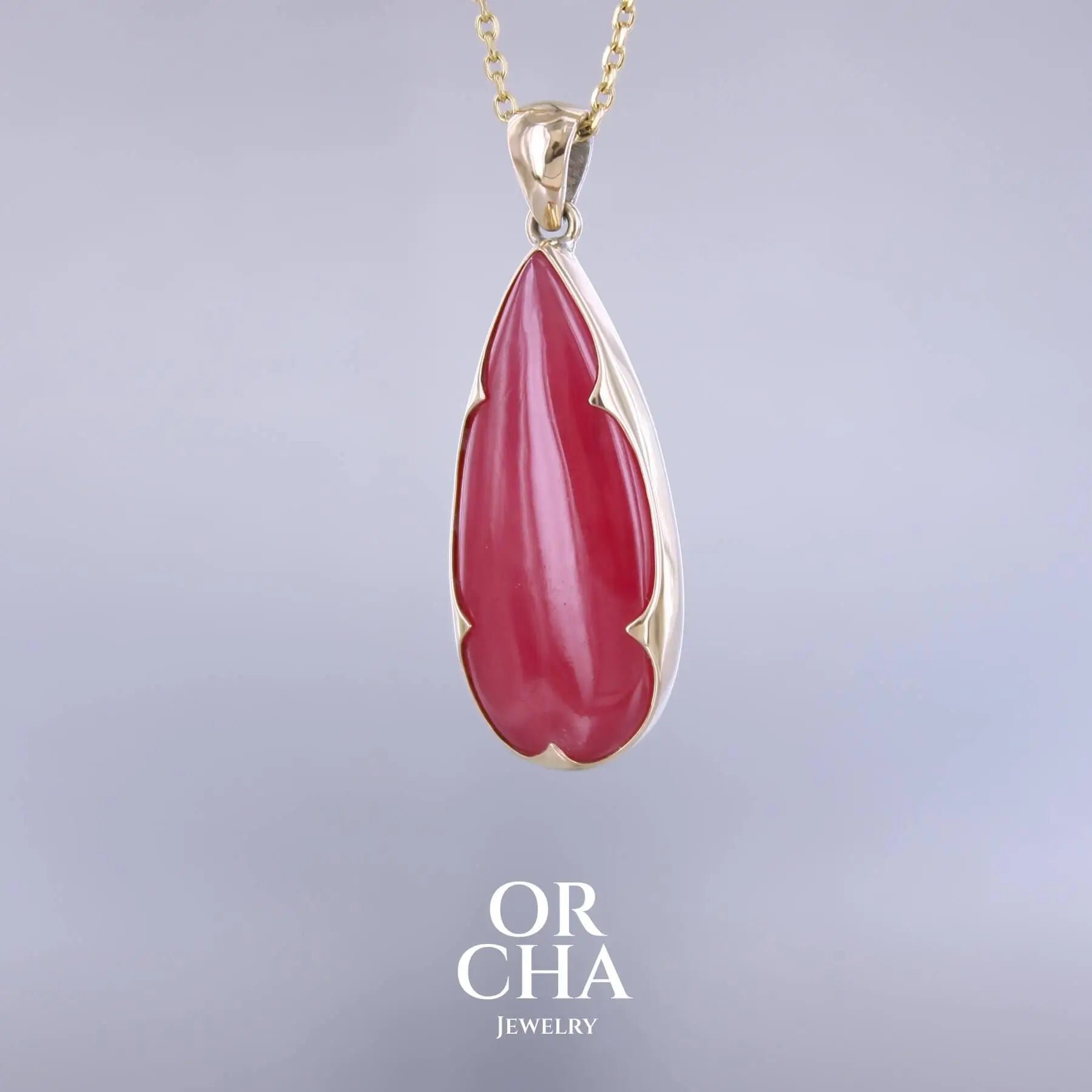 Pendentif pour femme en or jaune massif 18k et argent massif serti d'une Rhodonite rouge coquelicot de qualité rare. Pierre naturelle taillée en cabochon en forme de goutte de qualité translucide. Bijoux unique, éthique et durable présenté dans un coffret de notre marque, prêt à offrir. Livraison offerte, certificat d'authenticité, service client