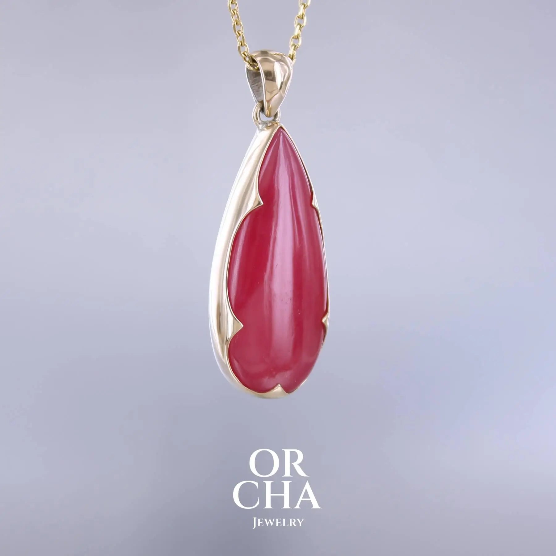 Pendentif pour femme en or jaune massif 18k et argent massif serti d'une Rhodonite rouge coquelicot de qualité rare. Pierre naturelle taillée en cabochon en forme de goutte de qualité translucide. Bijoux unique, éthique et durable présenté dans un coffret de notre marque, prêt à offrir. Livraison offerte, certificat d'authenticité, service client