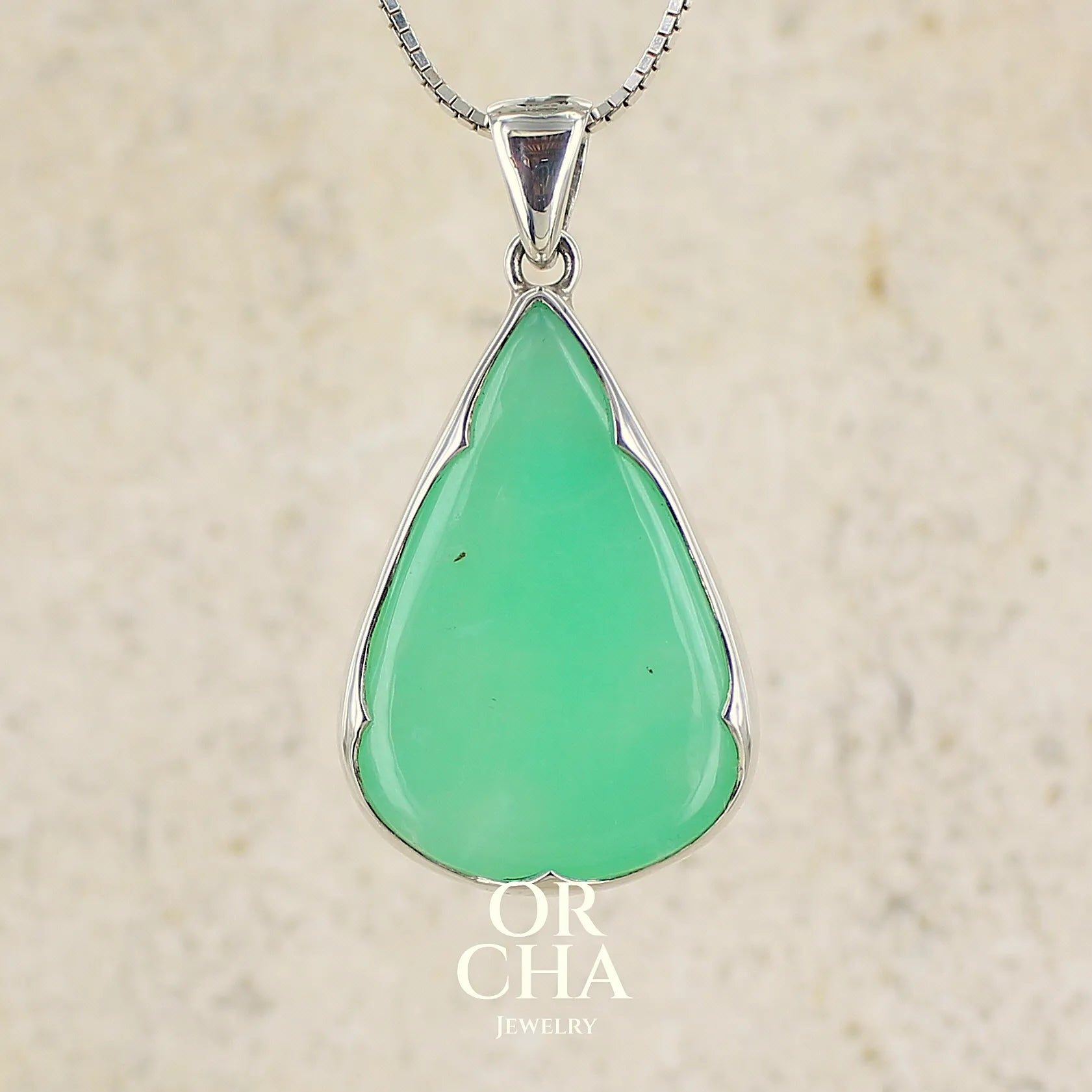 Pendentif pour femme en argent massif, sertie d'un cabochon de chrysoprase de couleur vert pomme. Cabochon de qualité translucide taillée en forme de goutte. Bijoux unique par Orcha jewelry