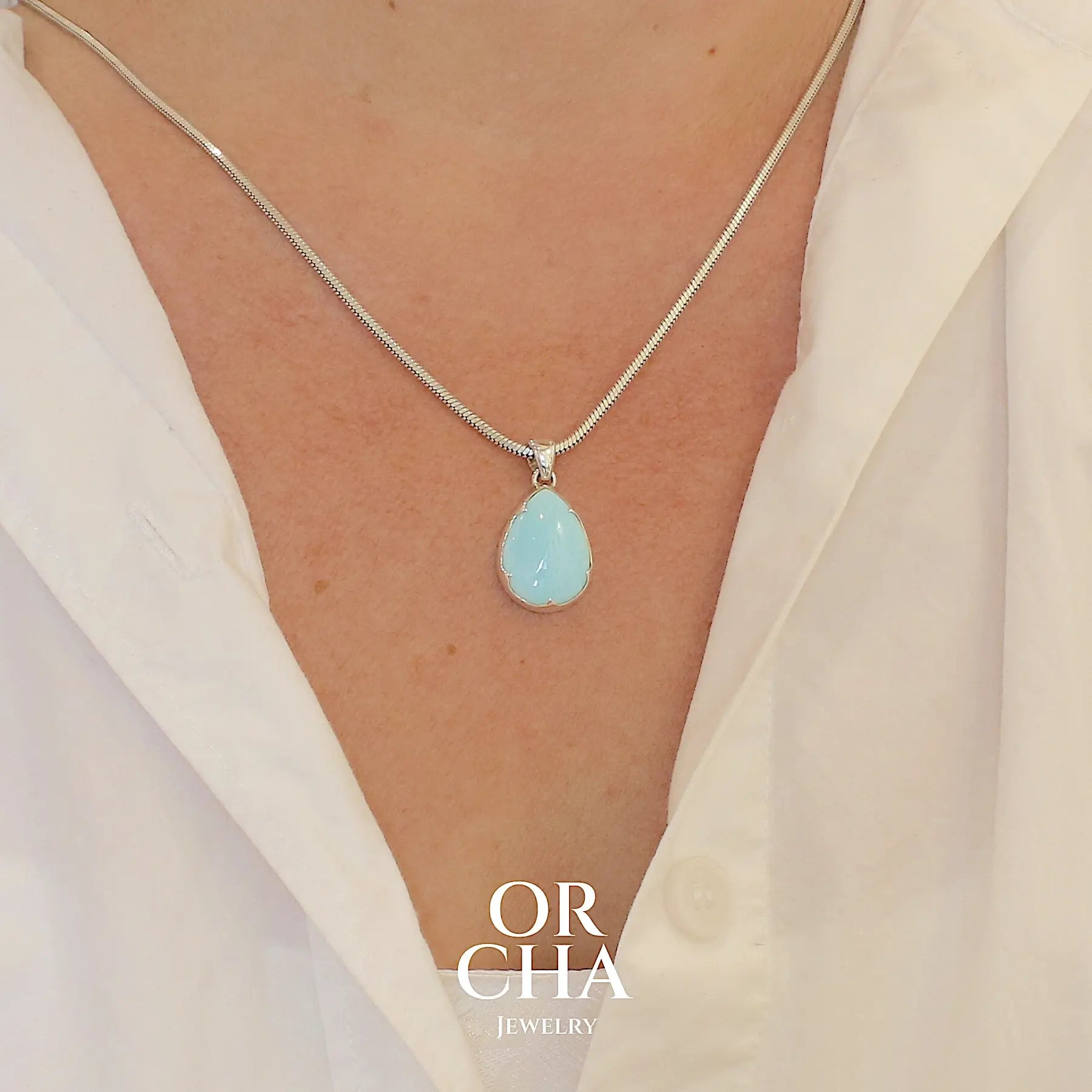 Pendentif pour femme en argent massif, sertie d'un cabochon d'opale bleue du Pérou de couleur bleu ciel clair. Pierre en forme de goutte. Pierre opaque. Bijoux unique, éthique et durable présenté dans un coffret de notre marque, prêt à offrir. Livraison offerte, certificat d'authenticité, service client.