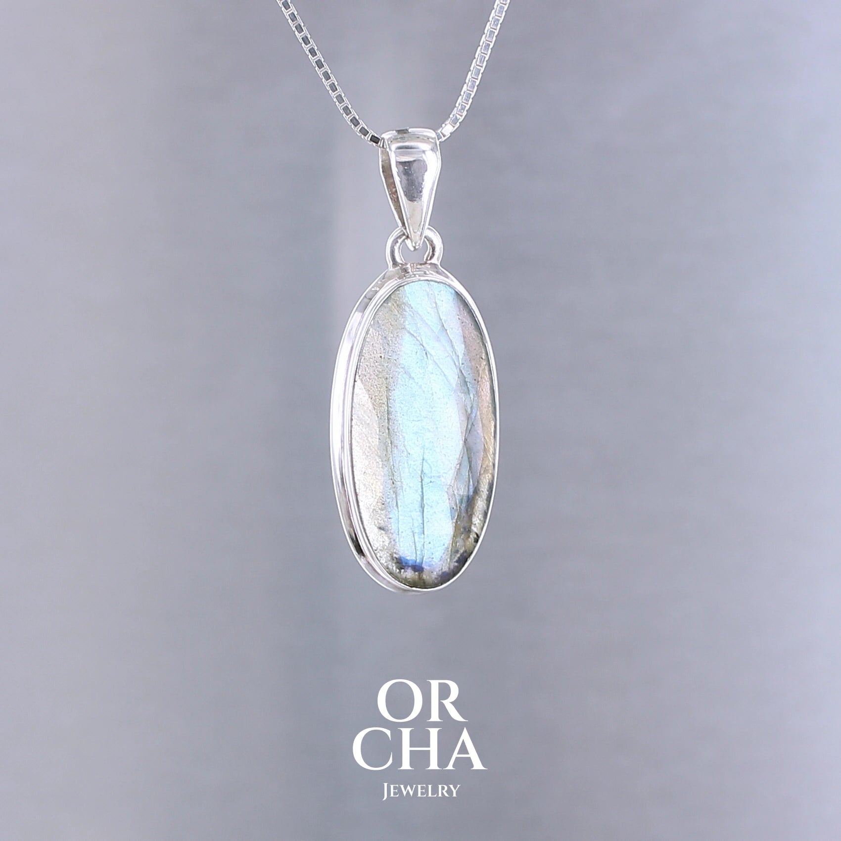 Pendentif pour femme en argent massif sertie d'une labradorite aux reflets bleus clairs selon la lumière. Pierre facettée naturelle translucide présentant des inclusions fréquents sur ce type de pierre. Bijoux unique, éthique et durable présenté dans un coffret de notre marque, prêt à offrir. Livraison offerte, certificat d'authenticité, service client.
