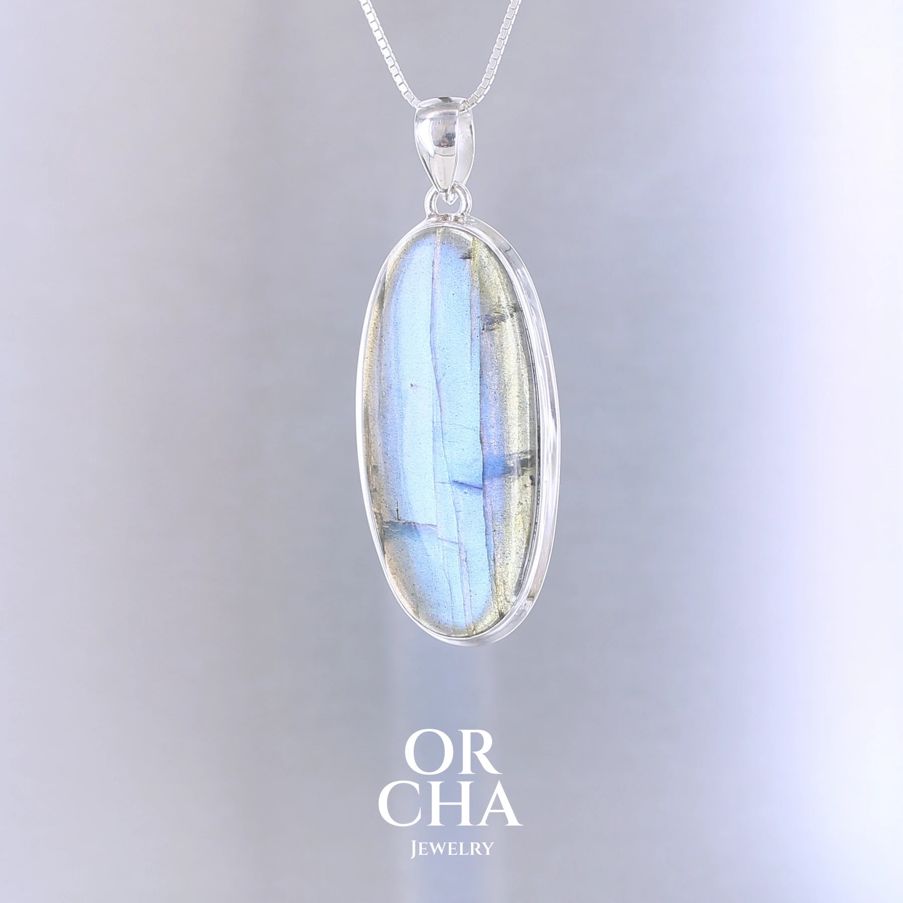 Pendentif ovale pour femme en argent massif sertie d'une labradorite aux reflets bleus électrique. Pierre cabochon naturelle translucide présentant des inclusions fréquents sur ce type de pierre. Bijoux unique, éthique et durable présenté dans un coffret de notre marque, prêt à offrir. Livraison offerte, certificat d'authenticité, service client.