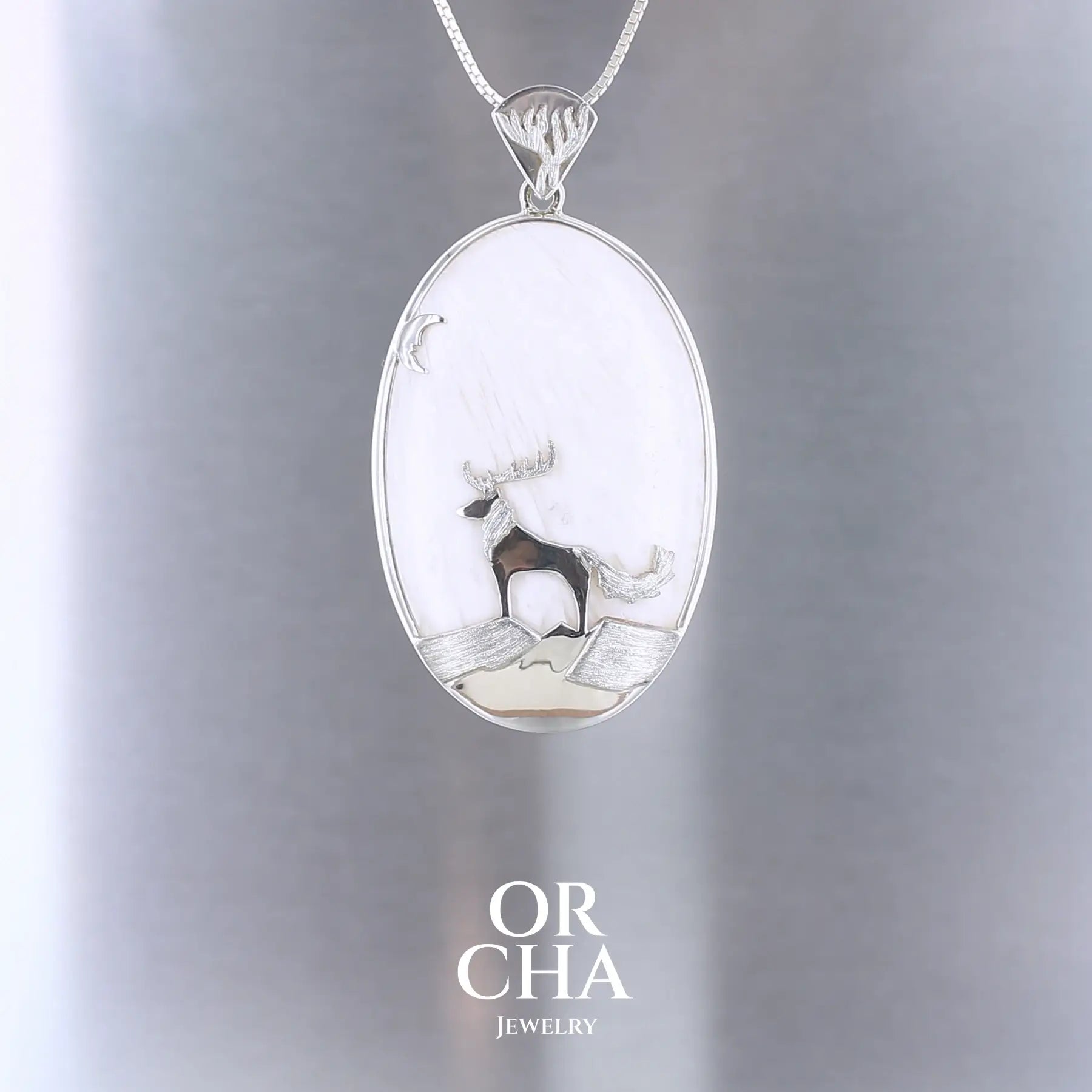 Pendentif de créateur en argent massif, où s'illustre un animal fantastique de type cerf loup sculpté en argent massif et serti sur un cabochon de scolécite. Pierre blanche opaque naturelle aux reflets soyeux. Bijoux unique, éthique et durable présenté dans un coffret de notre marque, prêt à offrir. Livraison offerte, certificat d'authenticité, service client.