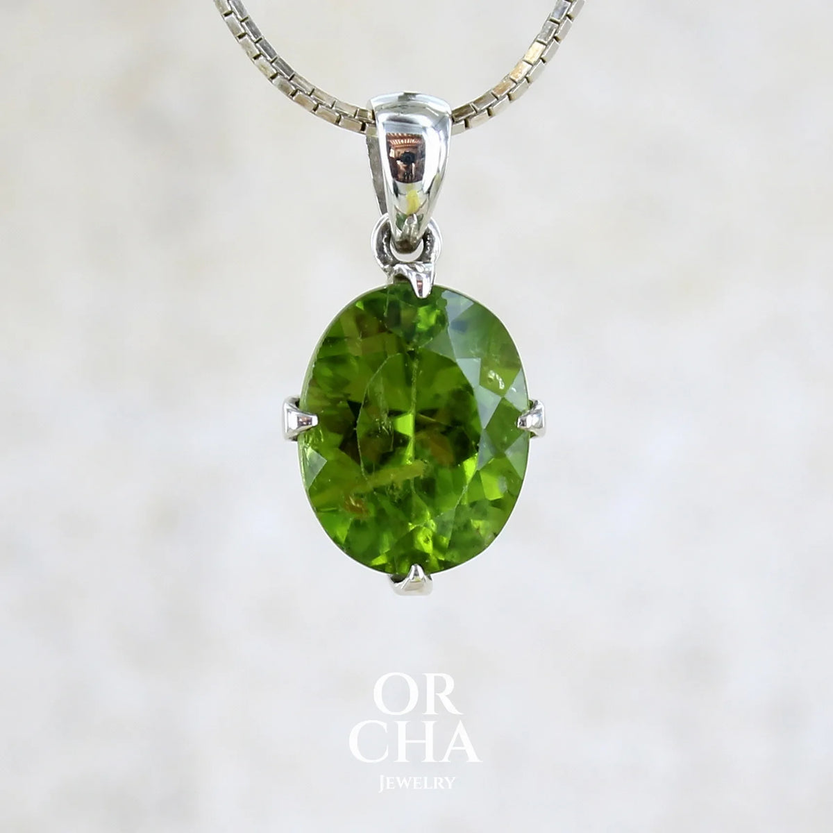 pendentif pour femme en argent massif serti d'un Péridot de couleur vert olive doré profond et intense . Pierre taillée transparente présentant des inclusions, de forme ovale. Bijoux unique par Orchajewelry