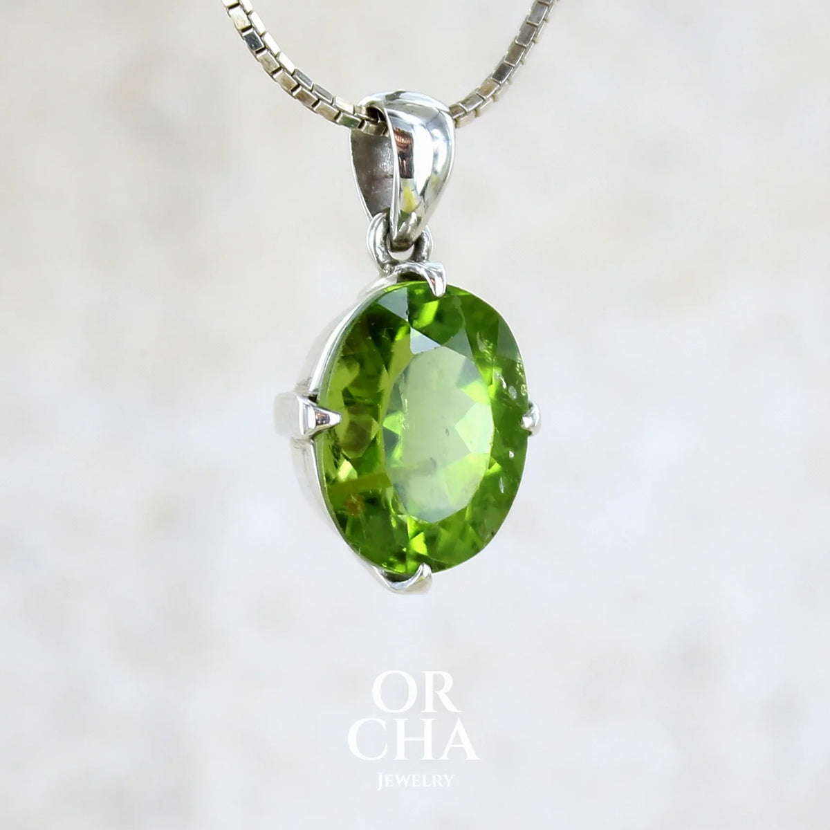 pendentif pour femme en argent massif serti d'un Péridot de couleur vert olive doré profond et intense . Pierre taillée transparente présentant des inclusions, de forme ovale. Bijoux unique par Orchajewelry