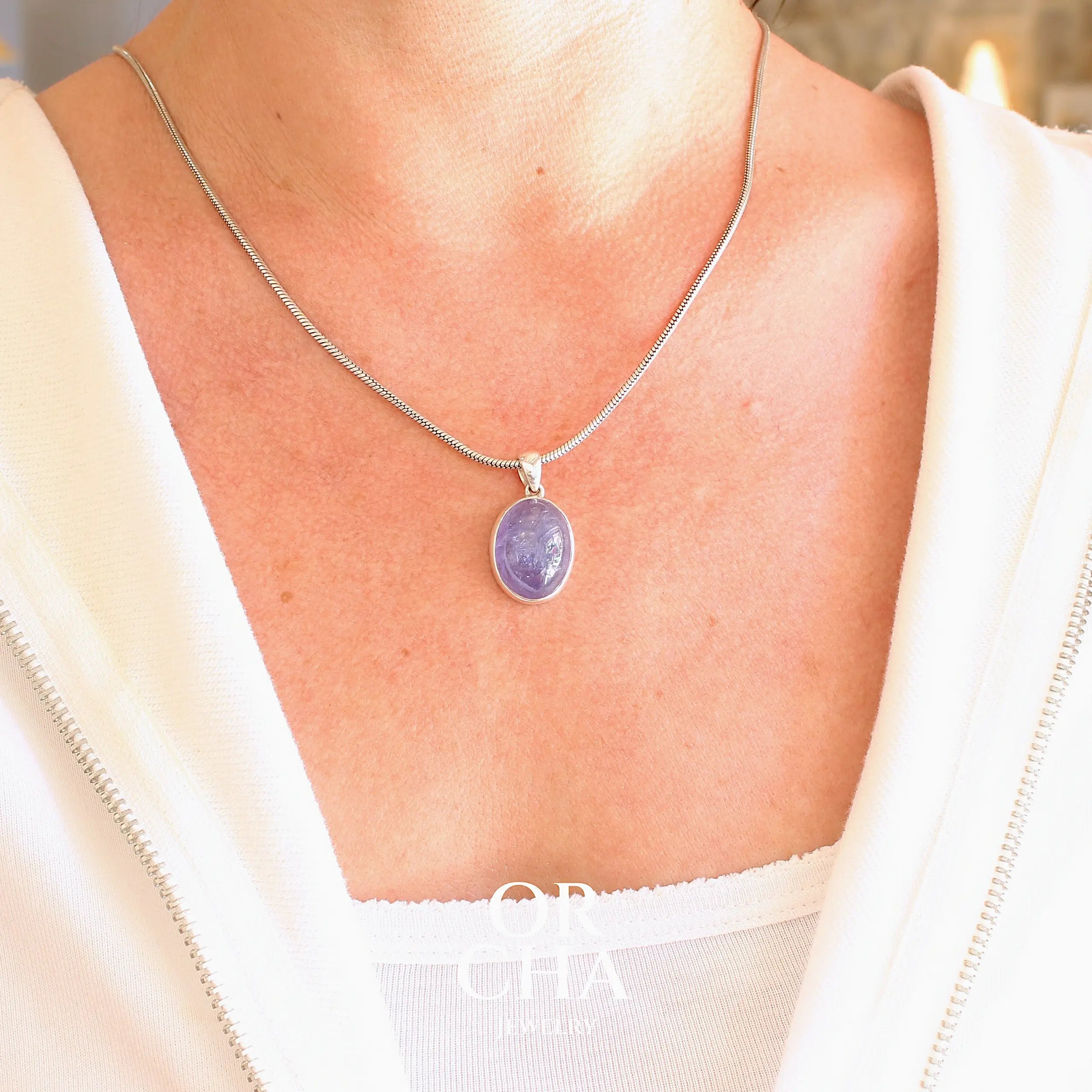 pendentif pour femme en argent massif serti d'un cabochon de Tanzanite de couleur bleu lavande foncé profond et intense . Pierre transparente présentant des inclusions. Pierre ayant subit un traitement de chauffe, traitement admis et fréquent en gemmologie pour ce type de pierre . Bijoux unique, éthique et durable présenté dans un coffret de notre marque, prêt à offrir. Livraison offerte, certificat d'authenticité, service client.
