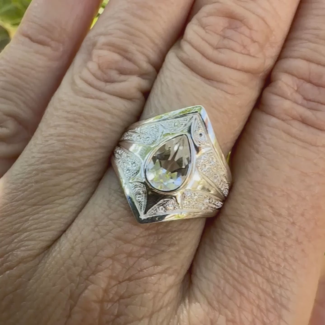 Bague pour femme en argent massif sculptées d'étoiles et autres corps célestes sertie d'une Topaze blanche.. Pierre facettée en forme de goutte, de couleur incolore, de qualité transparente ayant un très bel éclat. Disponible en plusieurs tailles. Bijoux unique, éthique et durable présenté dans un coffret de notre marque, prêt à offrir. Livraison offerte, certificat d'authenticité, service client.