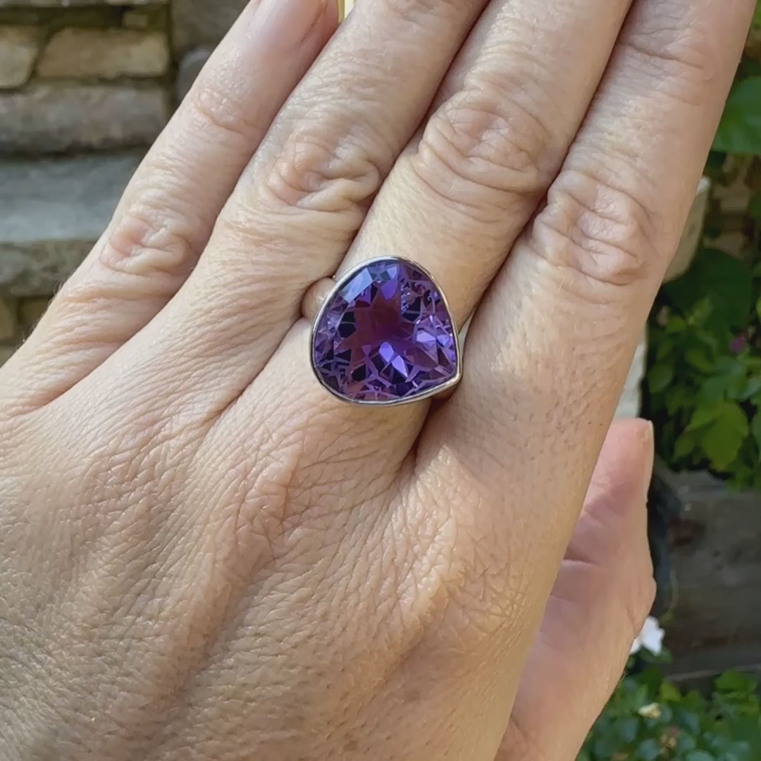 Bague cocktail pour femme en argent massif sertie d'une Améthyste. Pierre facettée en forme de goutte de qualité transparente, propre à l'oeil. Pierre naturelle de couleur violette clair gravée de motifs géométriques de fleur de vie. Tailles 60. Bijoux unique, éthique et durable présenté dans un coffret de notre marque, prêt à offrir. Livraison offerte, certificat d'authenticité, service client.