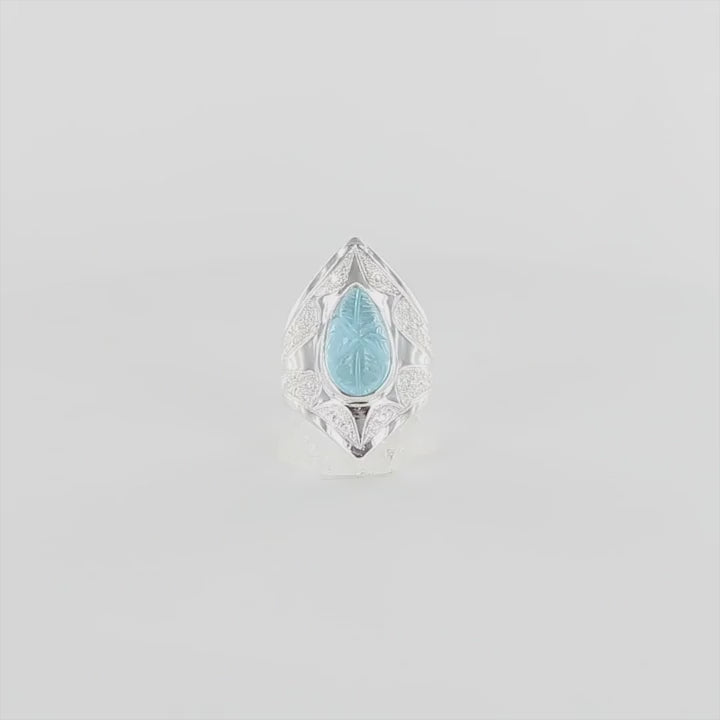Bague pour femme en argent massif sculptées d'étoiles et autres corps célestes sertie d'une Topaze bleue. Cabochon sculptée en feuille de couleur bleu ciel en forme de goutte. Bague réalisée en taille 54. Bijoux unique, éthique et durable présenté dans un coffret de notre marque, prêt à offrir. Livraison offerte, certificat d'authenticité, service client.