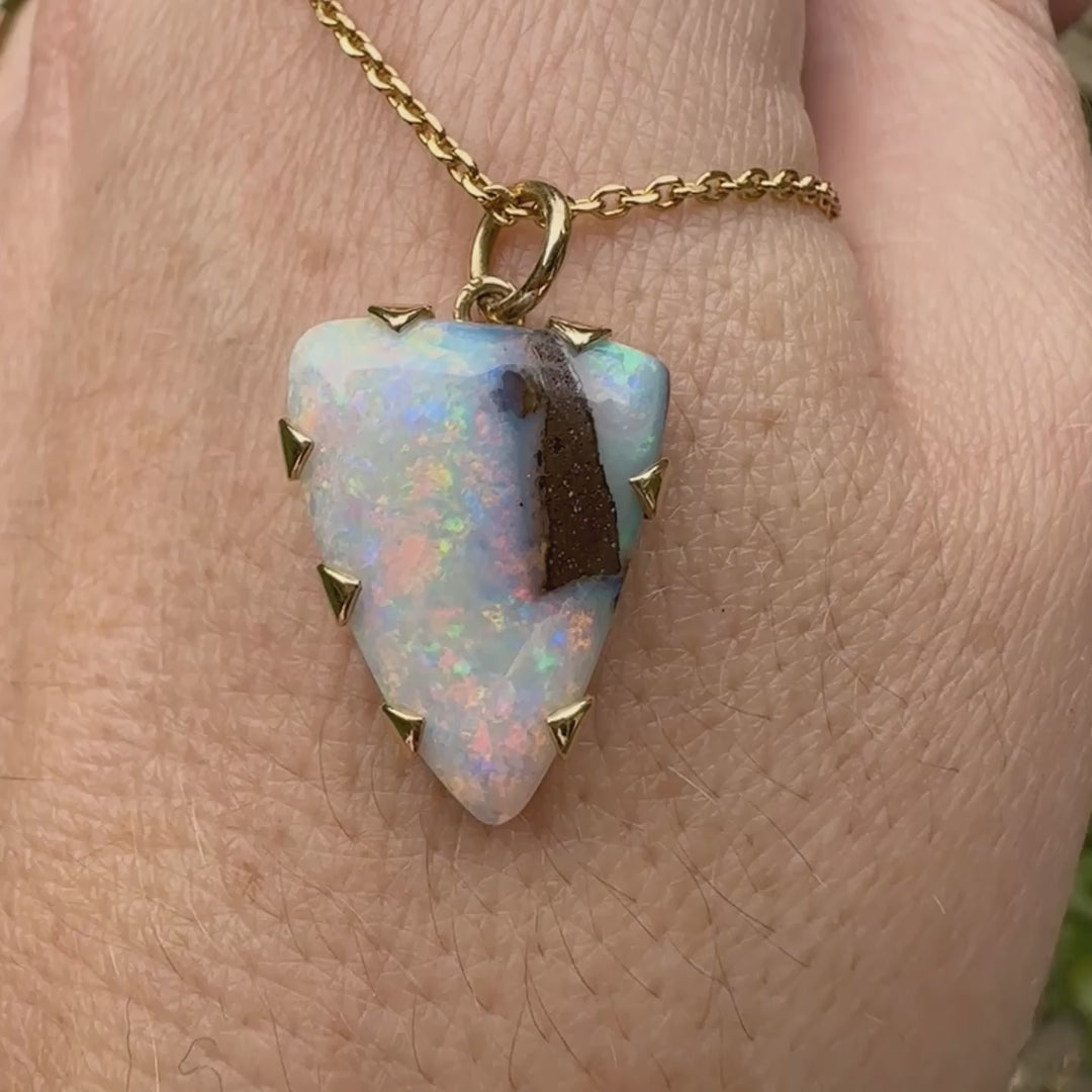 Pendentif pour femme en or jaune massif 18k serti d'une opale boulder aux feux multicolores. Majoritairement blanche une inclusion de matrice brune ressort en surface de la pierre, lui conférant un charme fou. Pierre naturelle taillée en cabochon de forme libre serti de griffe. Bijoux unique, éthique et durable présenté dans un coffret de notre marque, prêt à offrir. Livraison offerte, certificat d'authenticité, service client
