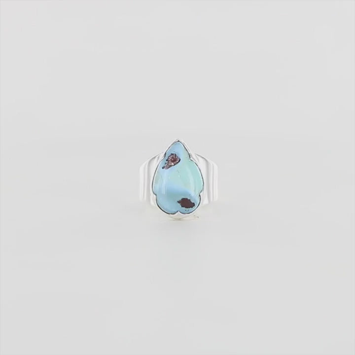 Bague de créateur en argent massif pour femme sertie d'une Turquoise Golden hill. Pierre cabochon en forme de goutte de qualité opaque. Pierre naturelle en camaïeu de bleu . Bague réalisée en taille 56. Bijoux unique, éthique et durable présenté dans un coffret de notre marque, prêt à offrir. Livraison offerte, certificat d'authenticité, service client.