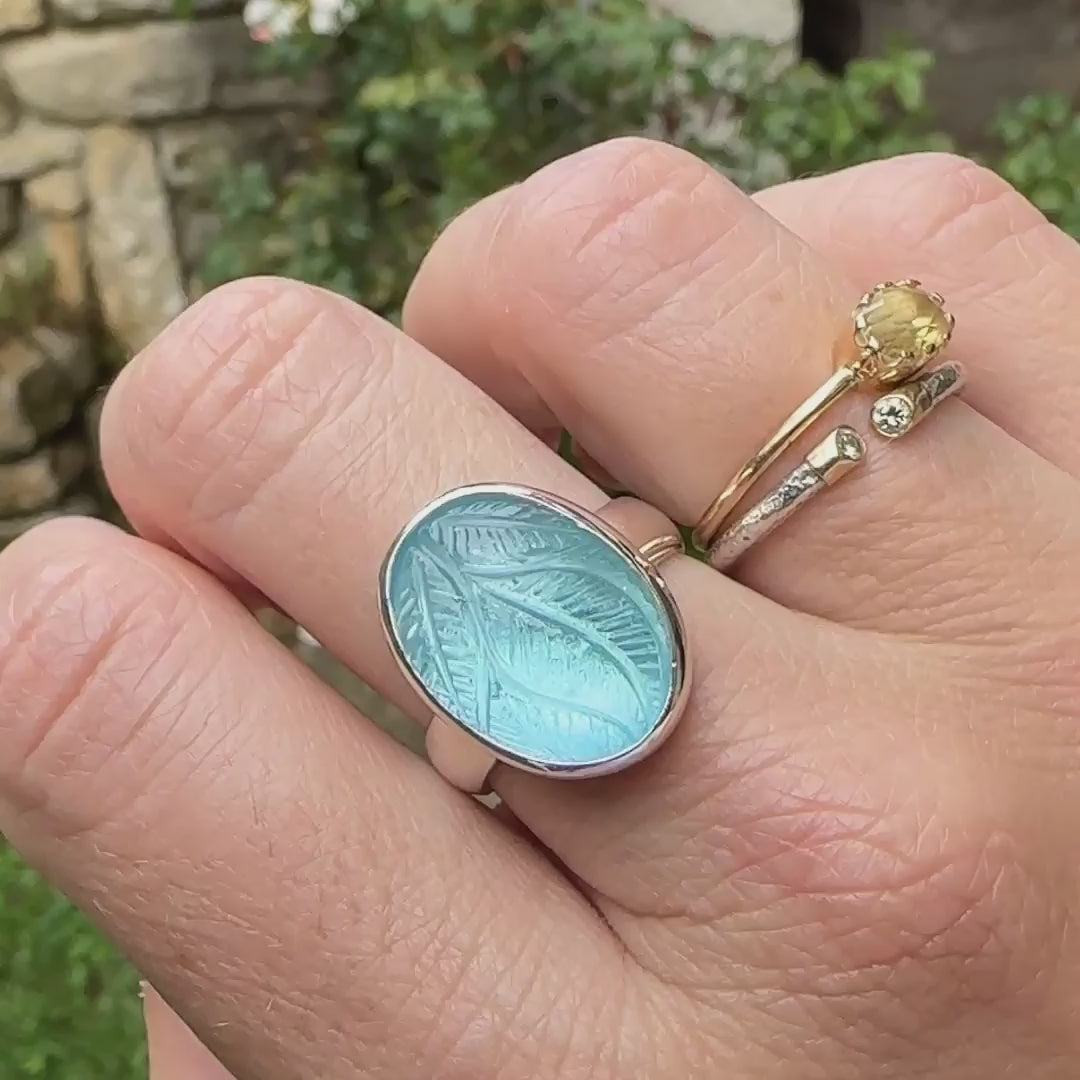 Bague florale pour femme en argent massif sertie d'une topaze bleue sculptée de motifs végétaux. Cabochon de forme ovale, pierre de couleur bleu ciel intense. Qualité transparente. Taille 57. Bijoux unique, éthique et durable présenté dans un coffret de notre marque, prêt à offrir. Livraison offerte, certificat d'authenticité, service client