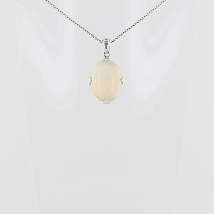 Pendentif pour femme en argent massif serti d'une pierre de lune orange clair, couleur chatoyante à effet satiné. Pierre naturelle taillée en cabochon de forme ovale serti de griffe. Bijoux unique, éthique et durable présenté dans un coffret de notre marque, prêt à offrir. Livraison offerte, certificat d'authenticité, service client