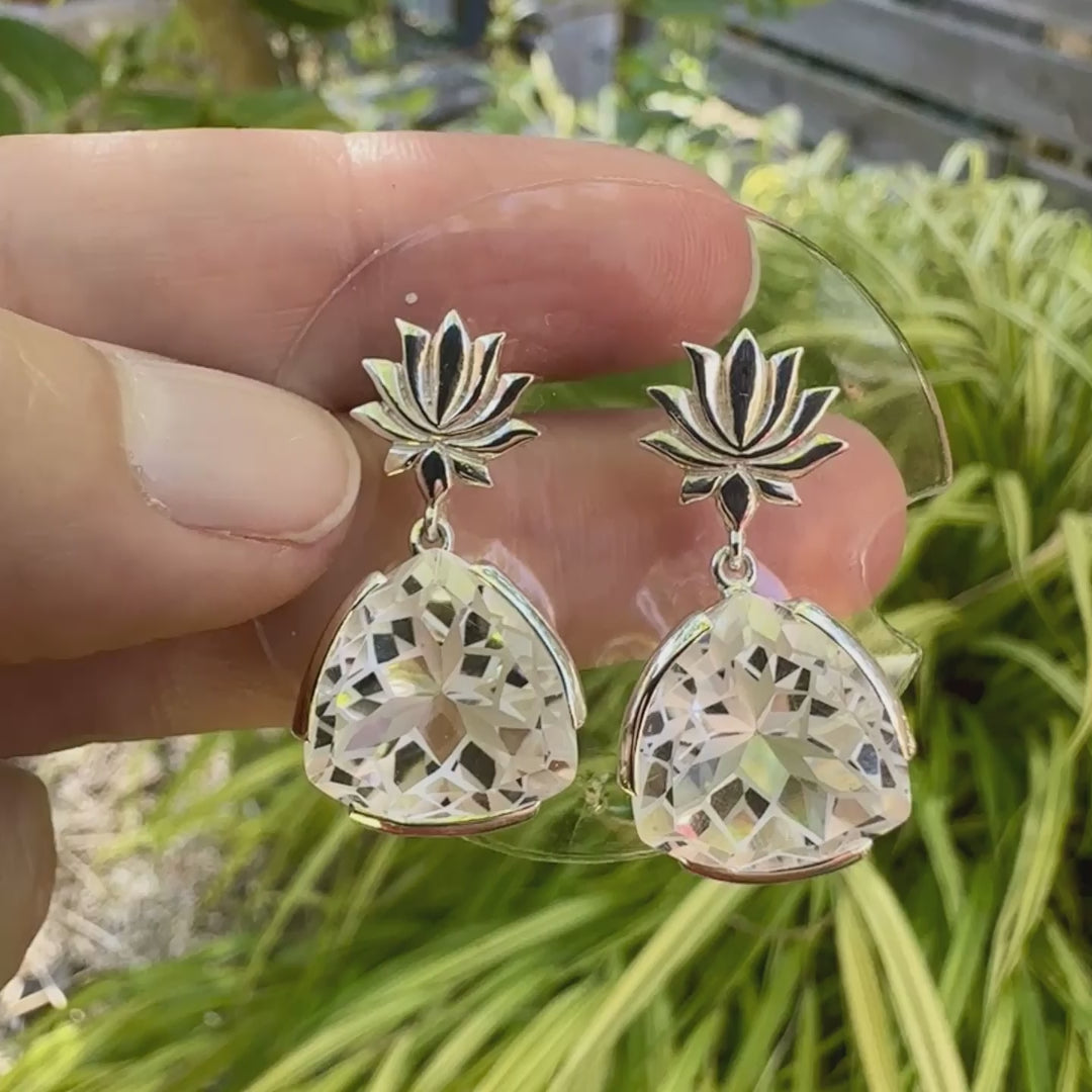 Boucles d'oreilles pour femme en argent massif sertie de Cristals de roche gravés de fleurs de vie. Pierres facettées de forme triangulaire de qualités transparentes, propre à l'oeil. Pierre naturelle incolore et blanche sur les parties gravées. Le clou des boucles représente un lotus. Bijoux unique, éthique et durable présenté dans un coffret de notre marque, prêt à offrir. Livraison offerte, certificat d'authenticité, service client.