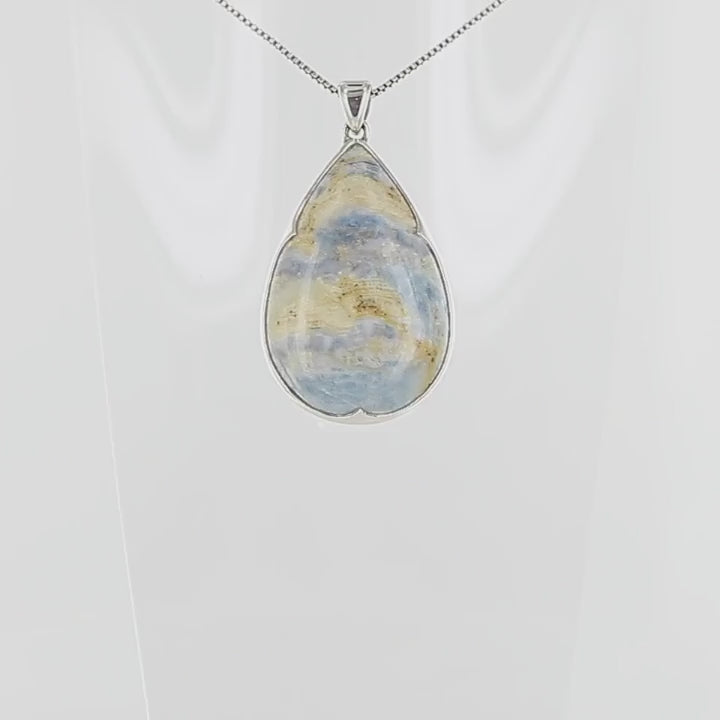 Pendentif pour femme en argent massif serti d'une Scheelite bleue. Pierre naturelle de couleur beige jaune et bleue ,taillée en cabochon en forme de goutte. Bijoux unique, éthique et durable présenté dans un coffret de notre marque, prêt à offrir. Livraison offerte, certificat d'authenticité, service client