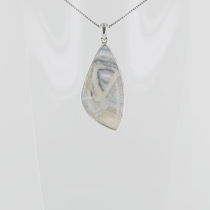 Pendentif pour femme en argent massif sertie d'une scheelite bleue. Pierre naturelle de couleur bleu, beige crème et blanc de qualité opaque. Bijoux unique, éthique et durable présenté dans un coffret de notre marque, prêt à offrir. Livraison offerte, certificat d'authenticité, service client.