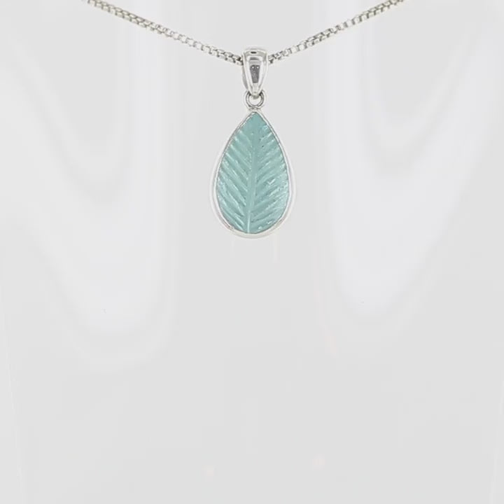 Pendentif pour femme en argent massif serti d'une topaze bleue sculptée en forme de feuille d'arbre. Pierre cabochon en forme de goutte de couleur bleu ciel lumineux. Bijoux unique, éthique et durable présenté dans un coffret de notre marque, prêt à offrir. Livraison offerte, certificat d'authenticité, service client.